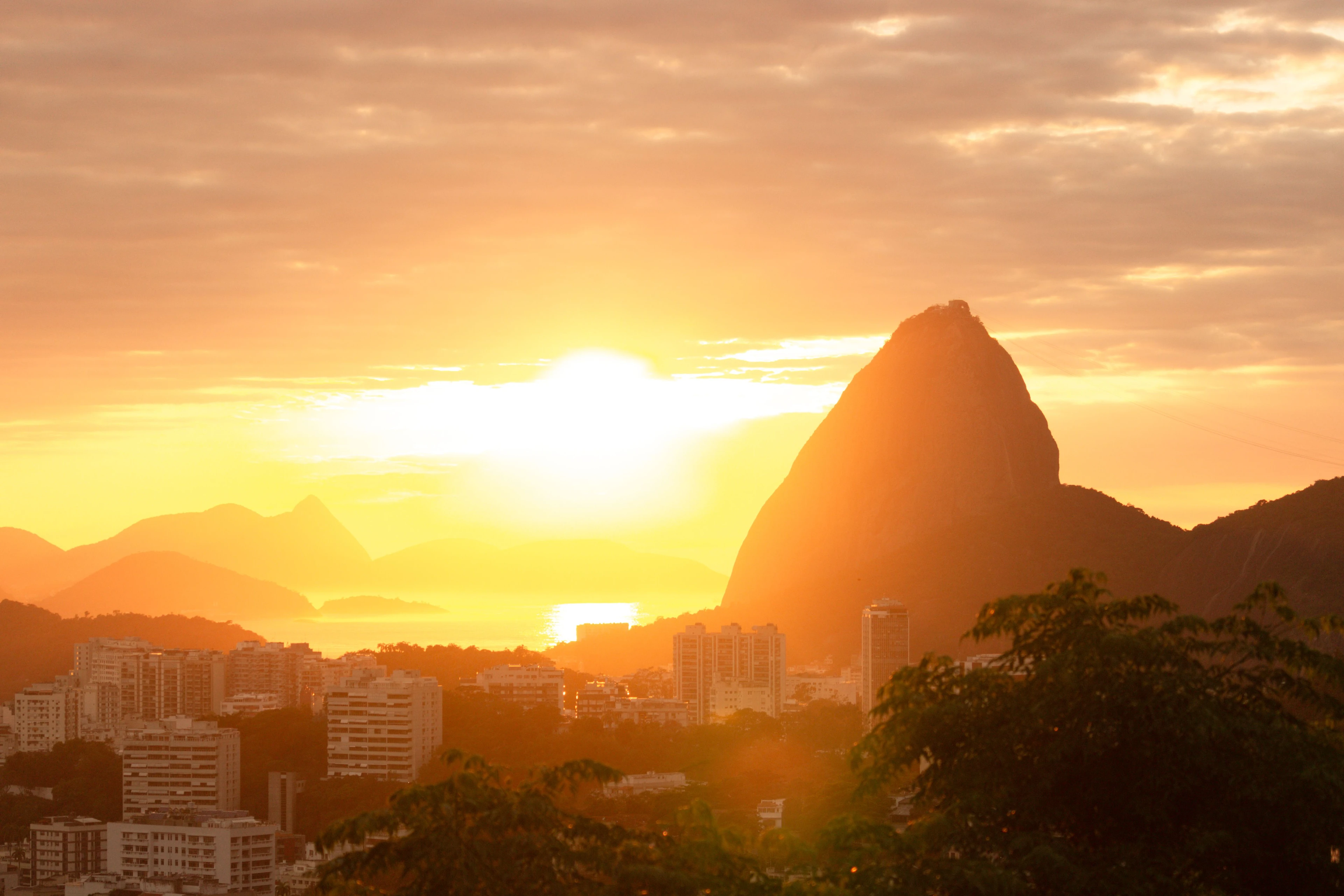 Sugarloaf and Rio’s hills silhouetted in golden light above the city