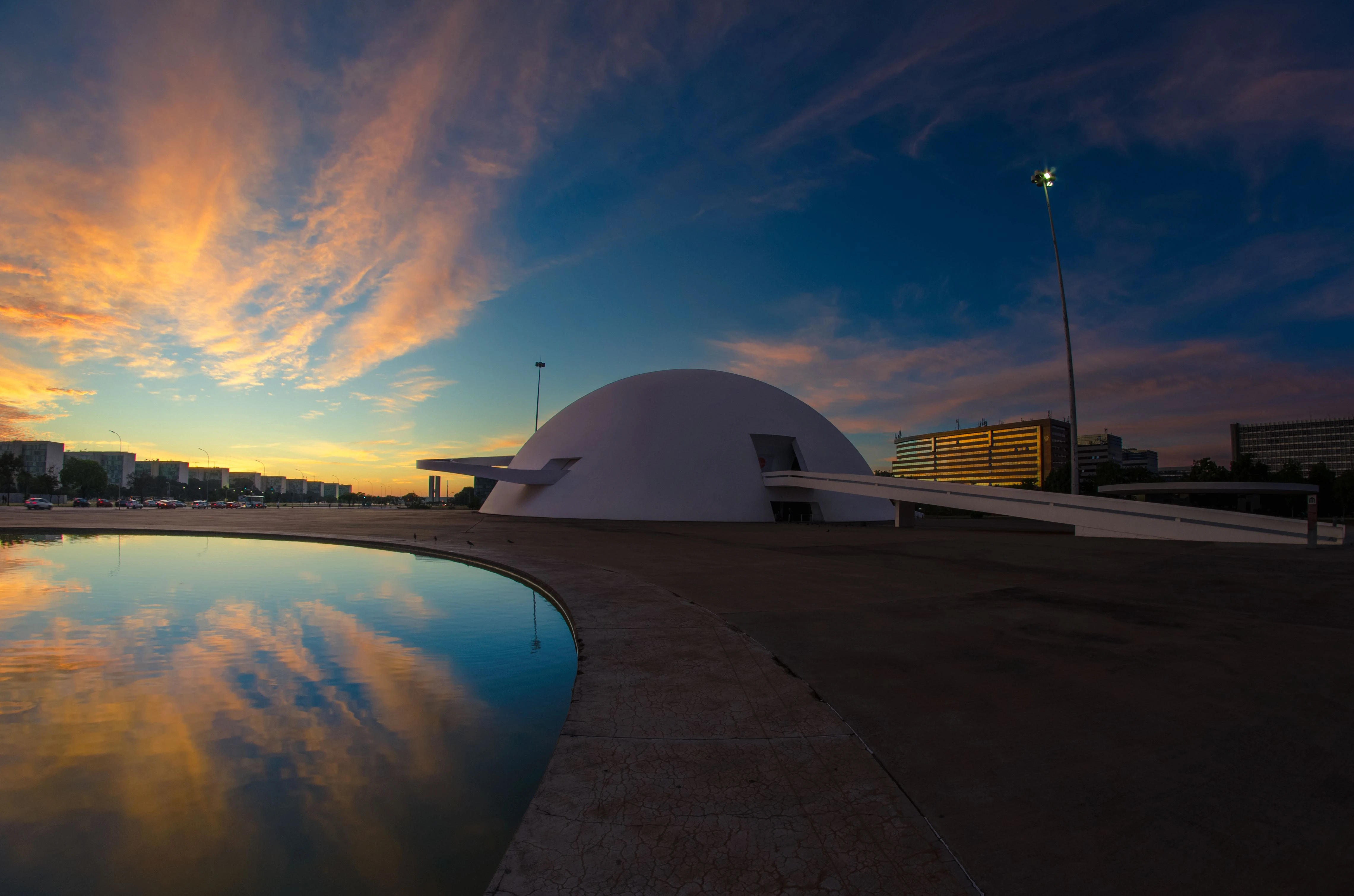 The curved National Museum and its reflection beneath a twilight sky in Brasília.