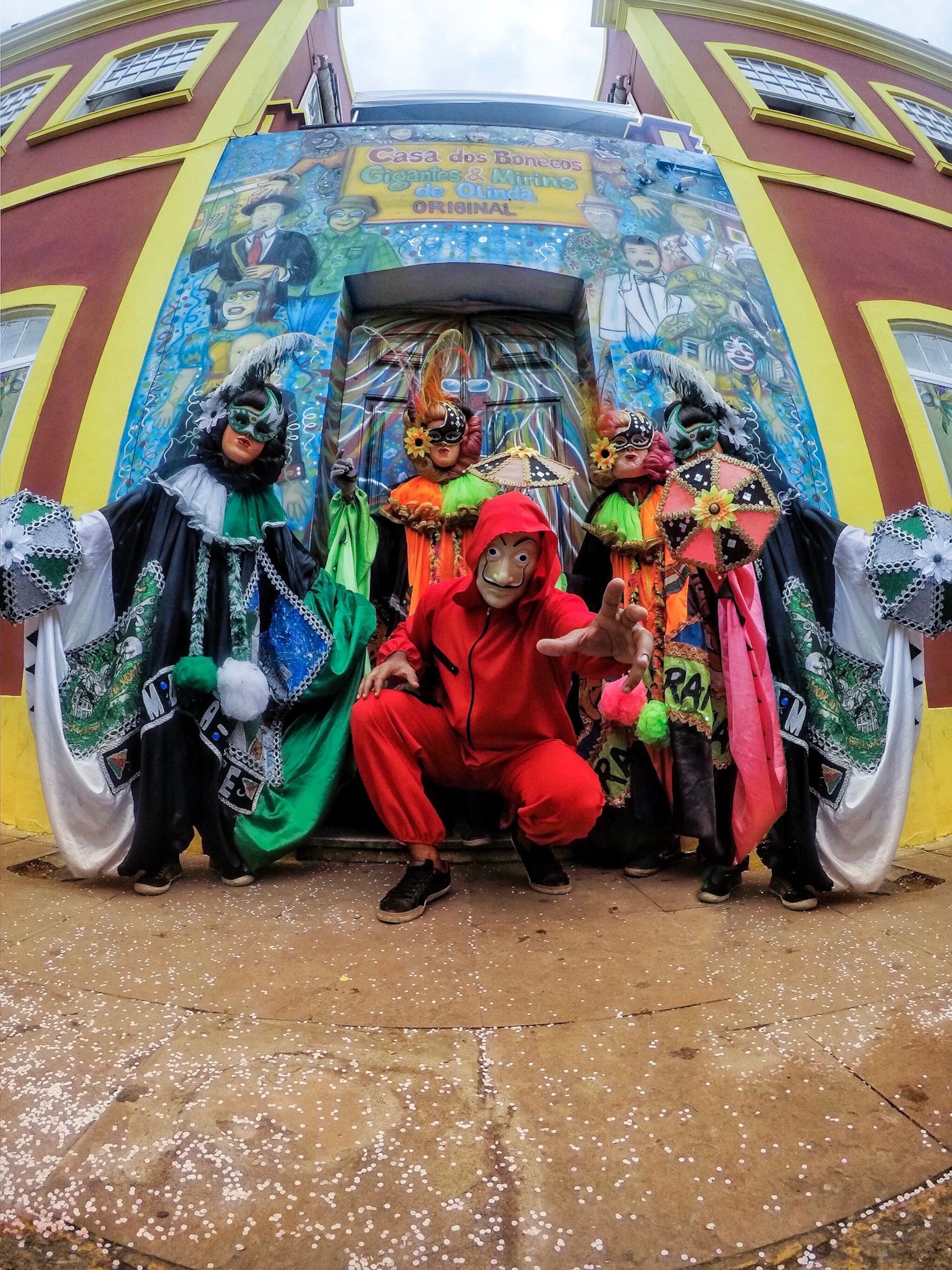 People in vivid costumes outside Olinda’s Casa dos Bonecos, seen at street level