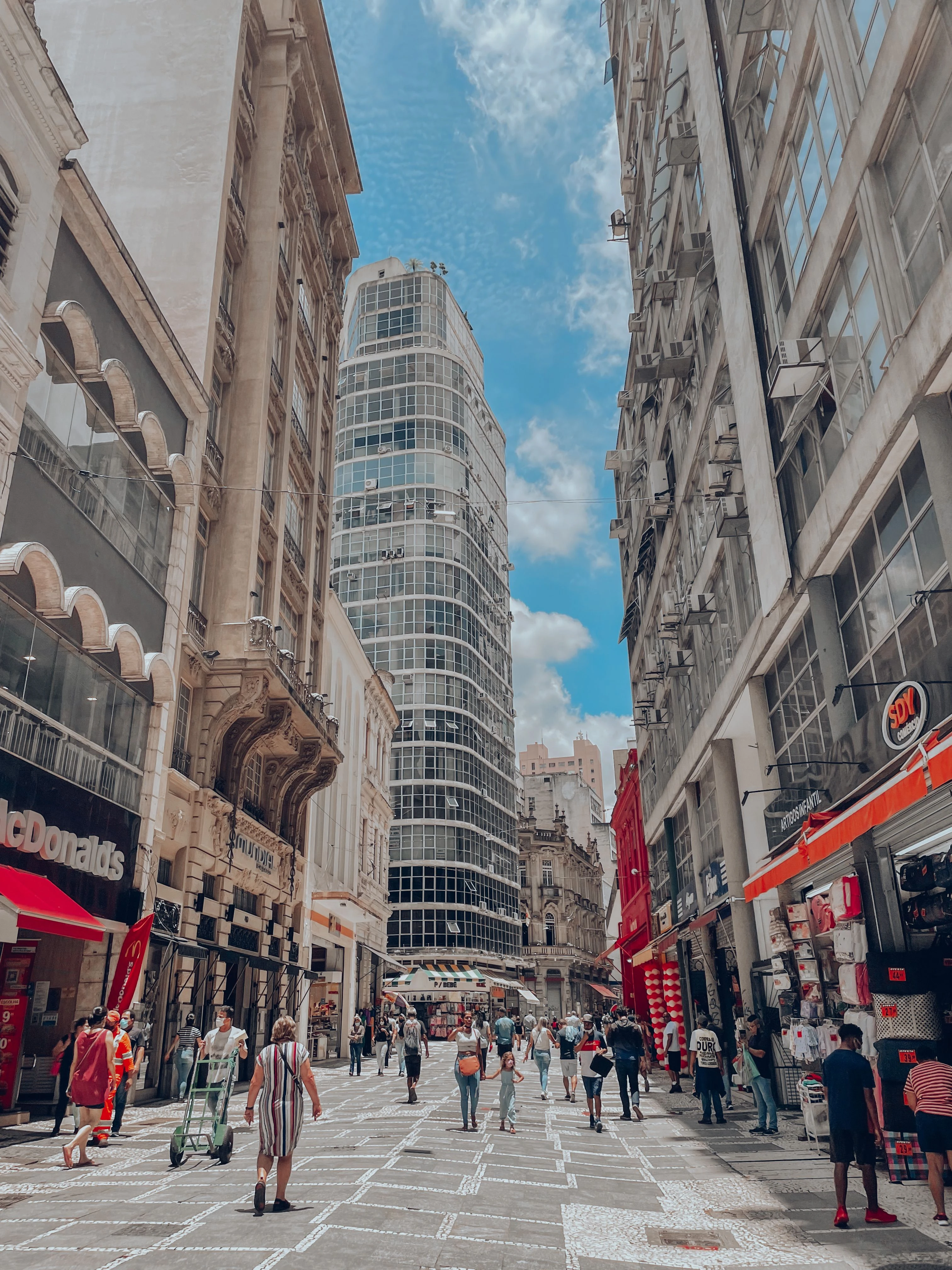 Pedestrians walk between historic and modern buildings in central São Paulo