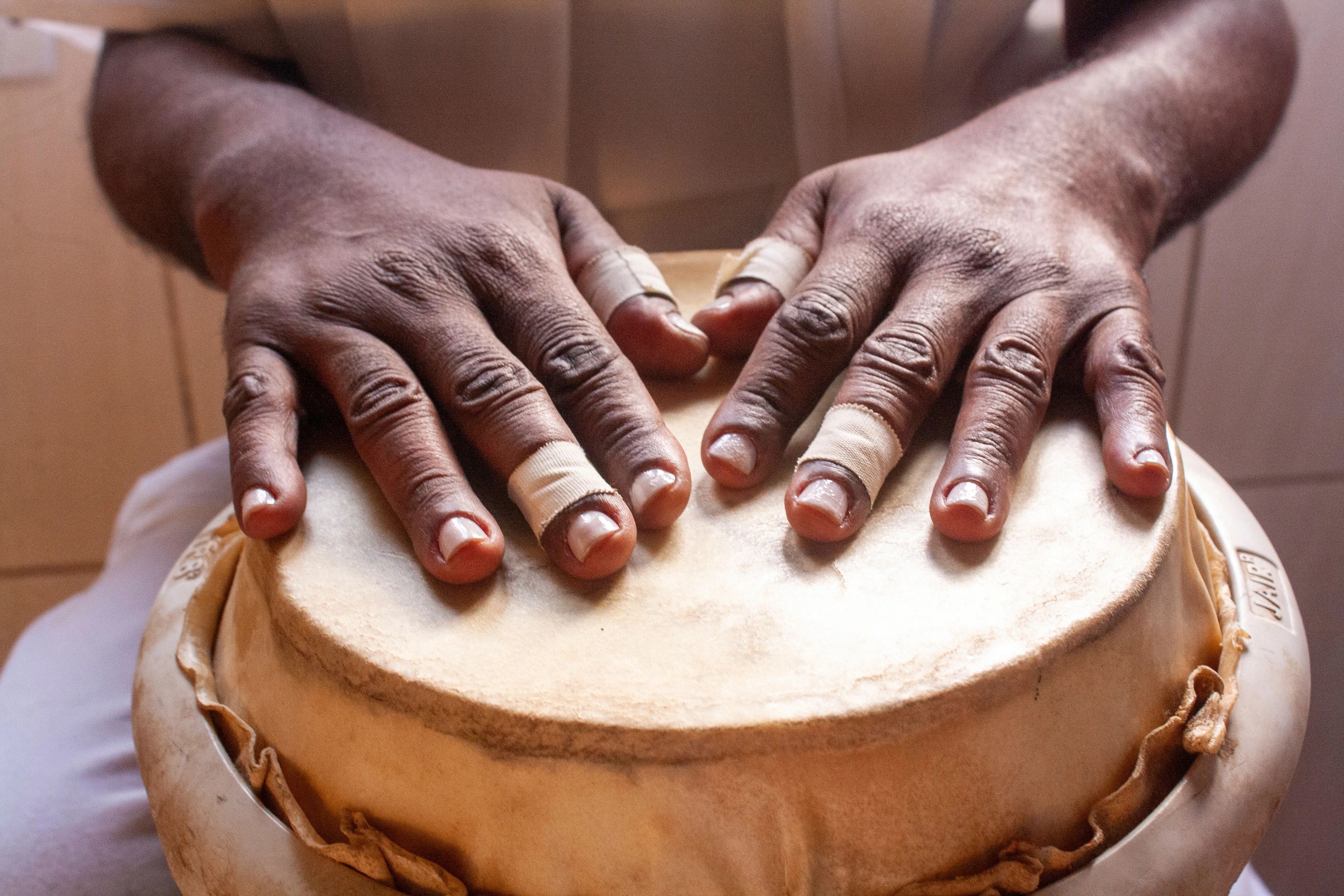A musician’s hands resting on a drum in São Paulo