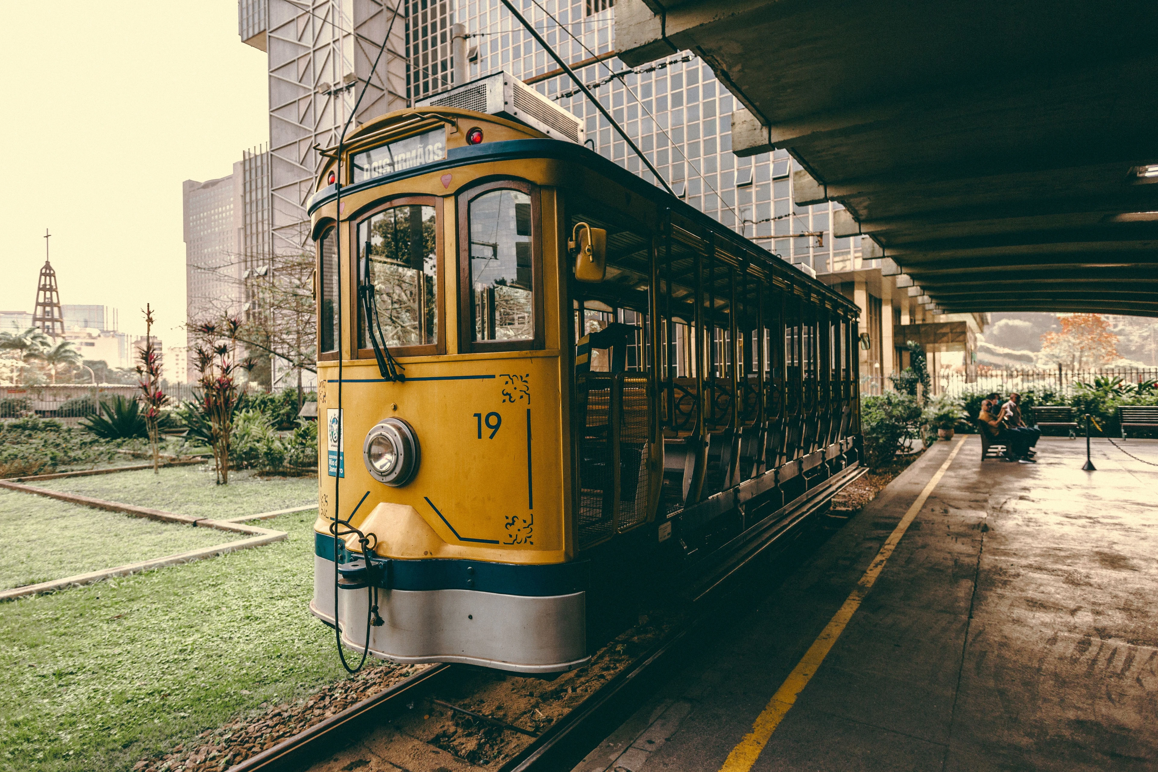 Yellow Santa Teresa tram seen from a low angle beside the city’s buildings