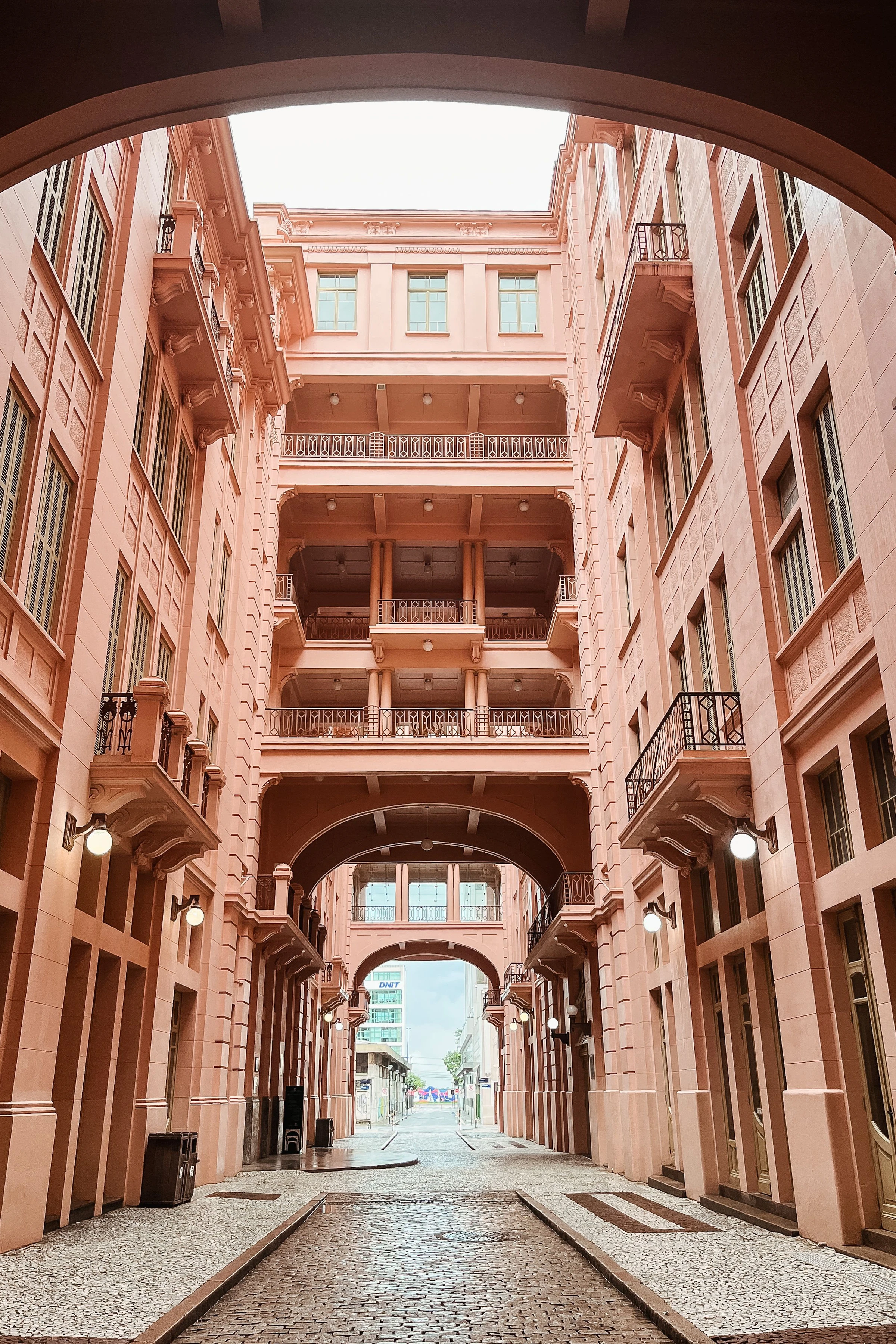 Pink facades and connecting arches create a deep architectural passage in Porto Alegre.
