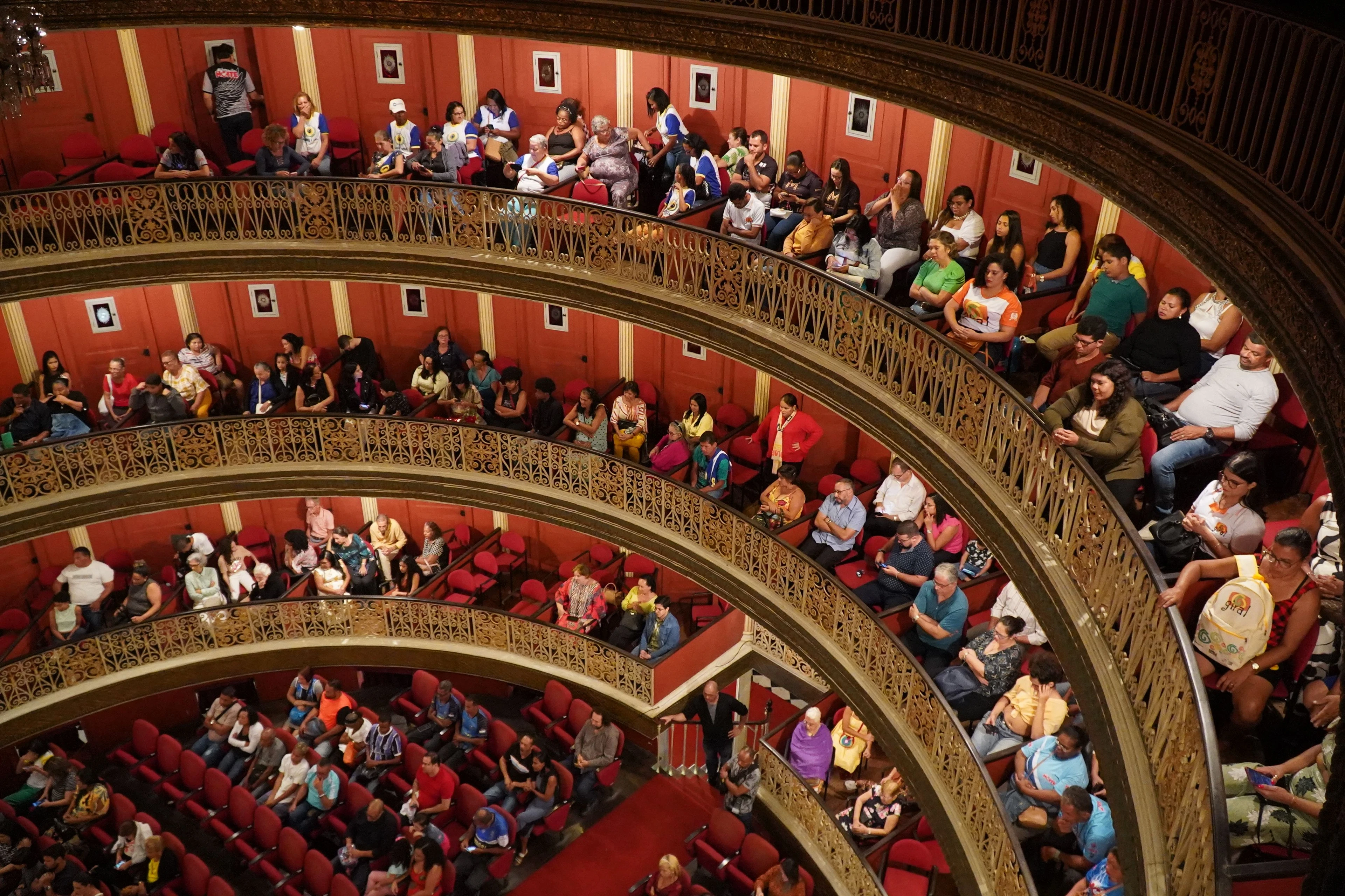 An audience filling curved red and gold balconies at Teatro Santa Isabel in Recife