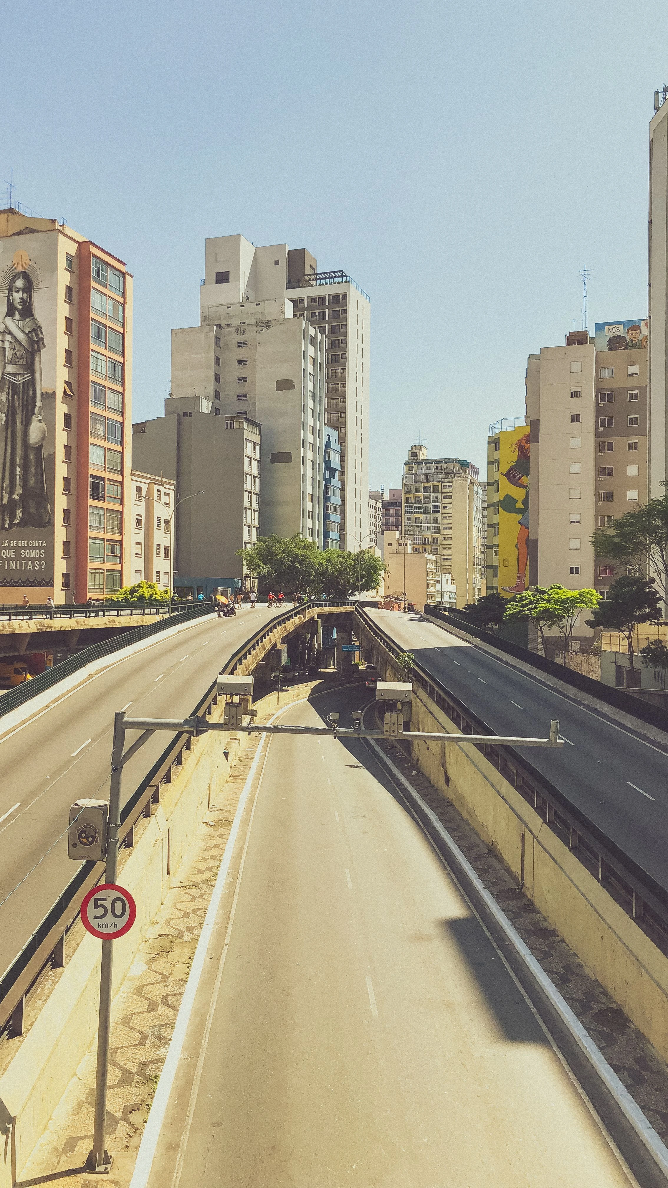 Pedestrians on Minhocão below São Paulo apartment buildings and murals