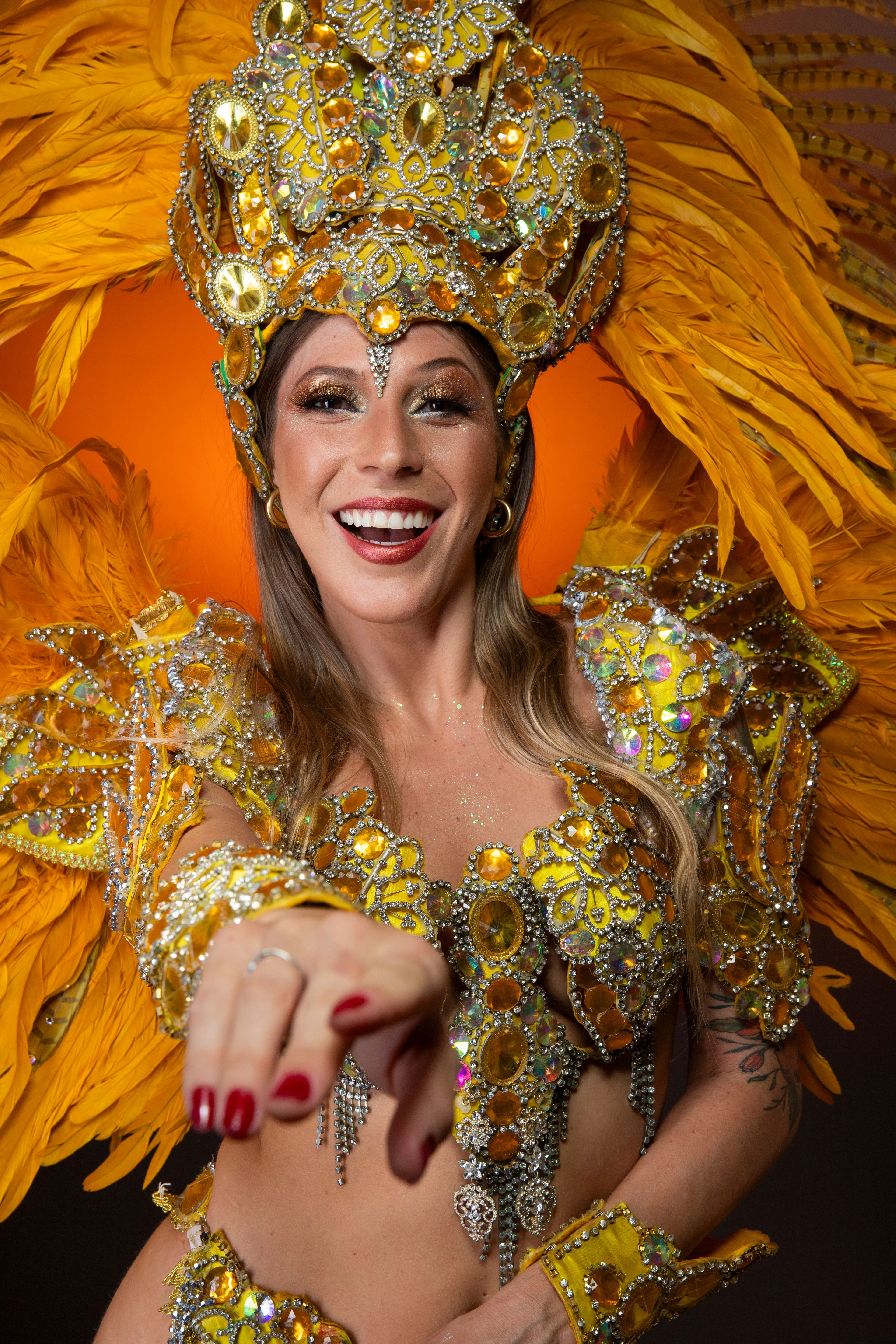 A smiling woman in an elaborate golden Carnival costume