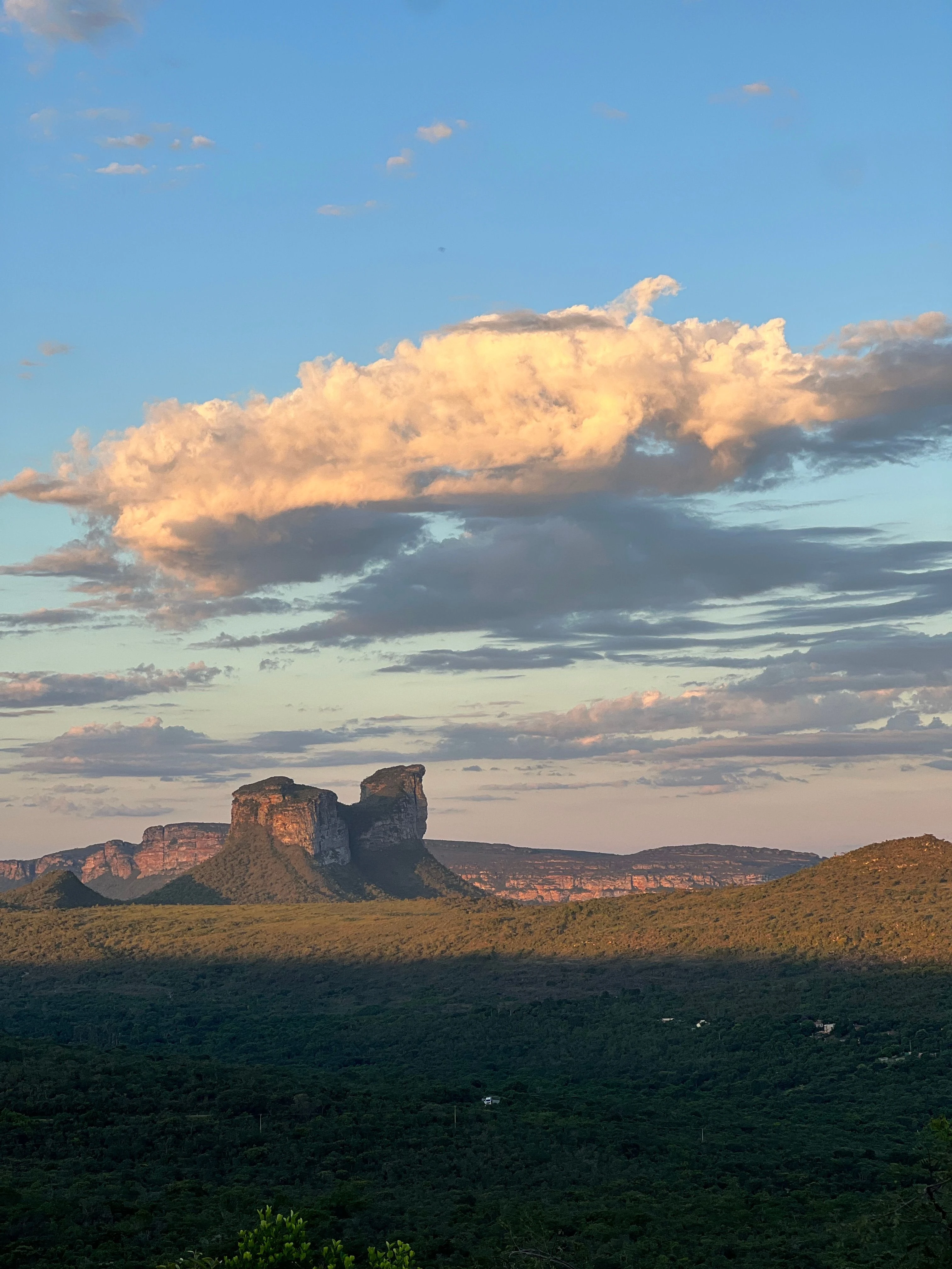 Twin rock towers beneath warm clouds in Chapada Diamantina, Bahia, shown as Brazilian upland context.