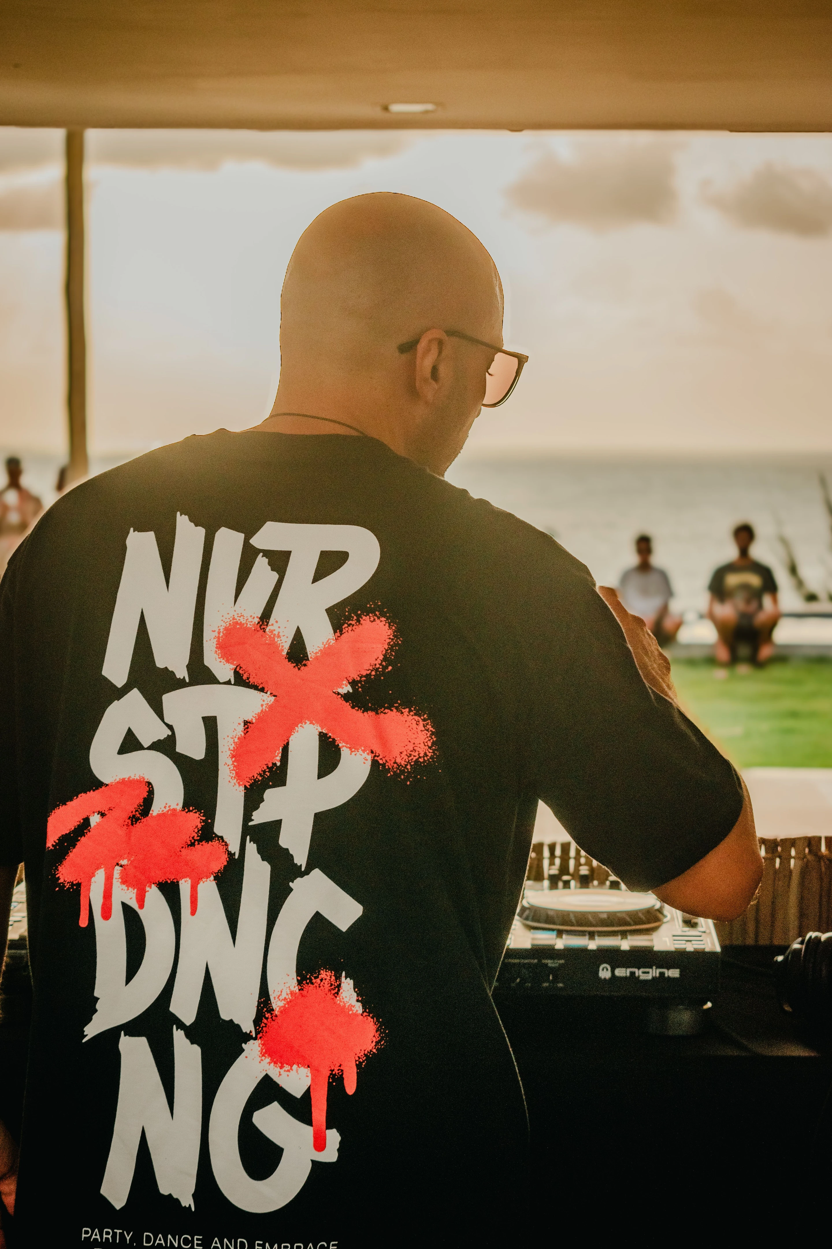 A DJ works at an outdoor beach gathering in Pipa