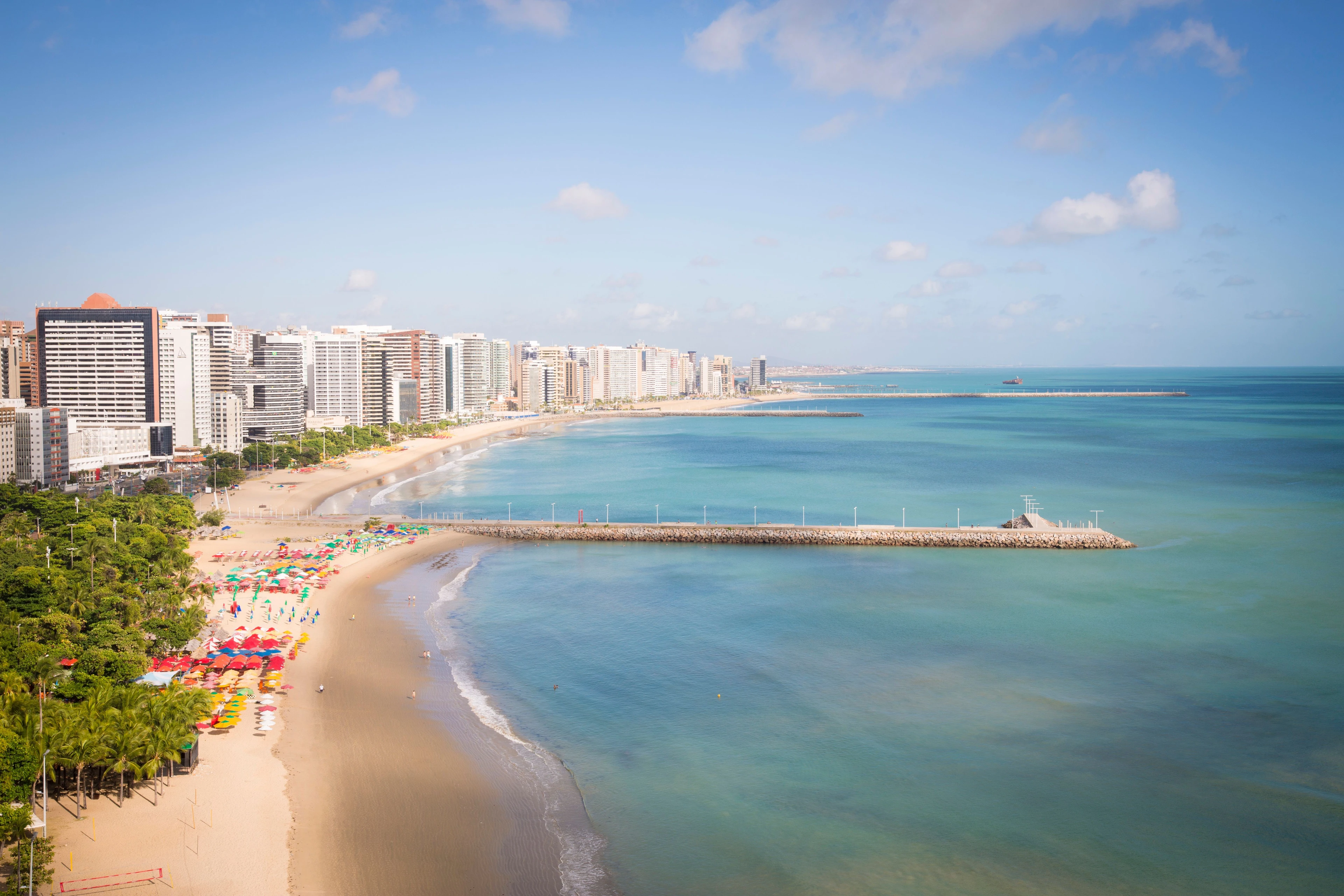 An aerial view of Fortaleza’s curving beach and dense oceanfront skyline