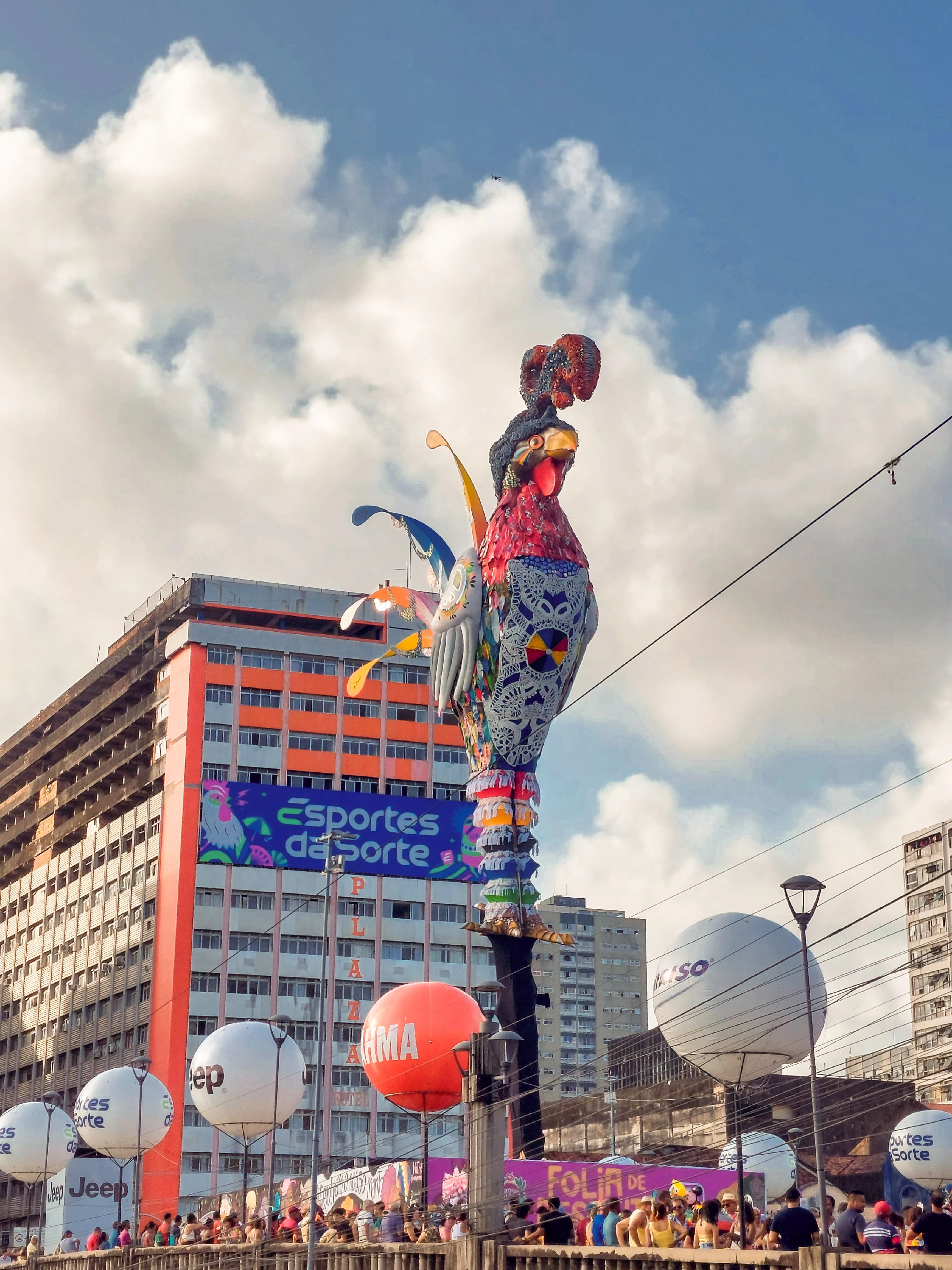The colorful Galo da Madrugada rooster rises above a Carnival crowd in Recife