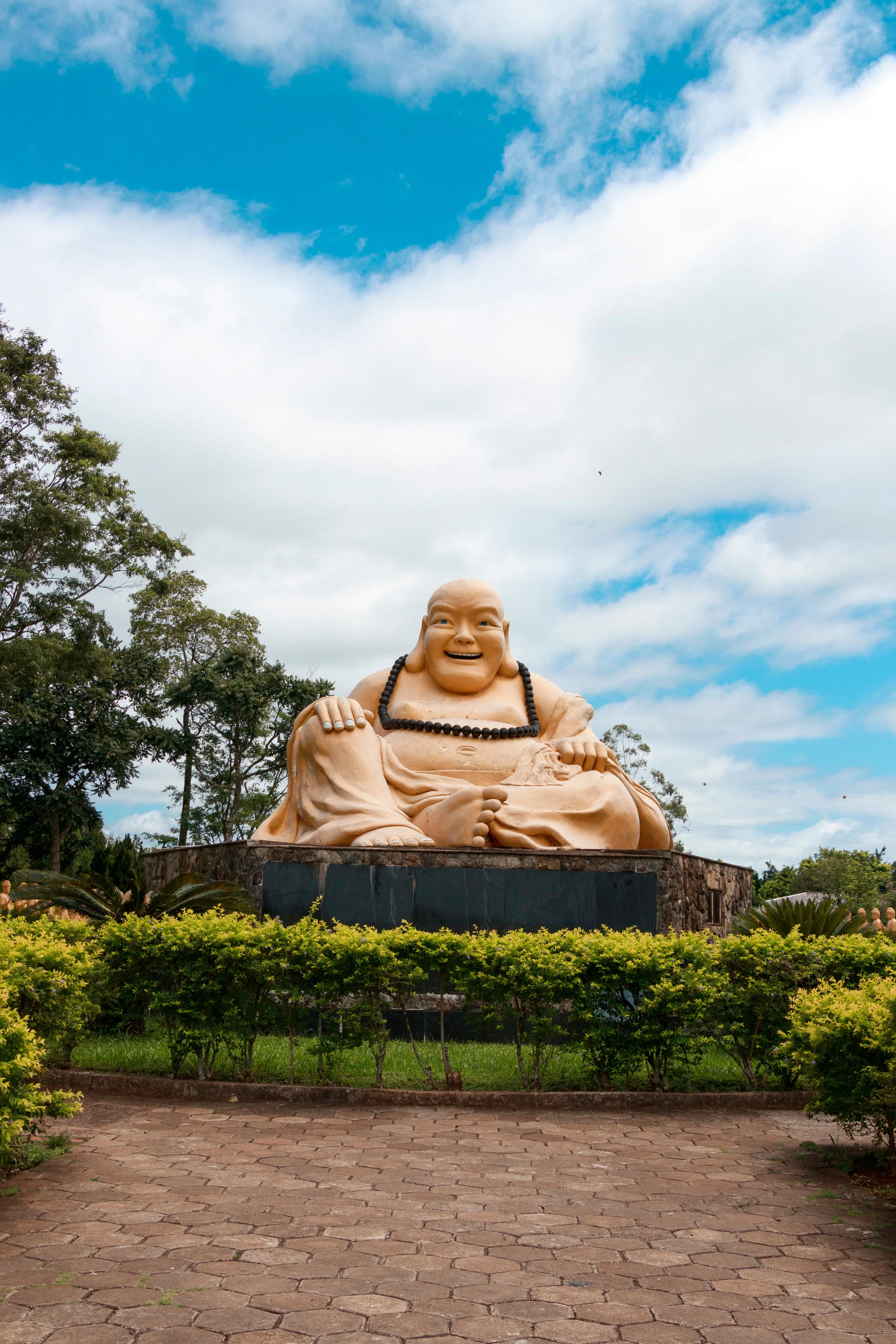 A towering Buddhist statue viewed from below against a bright sky in Foz do Iguaçu.