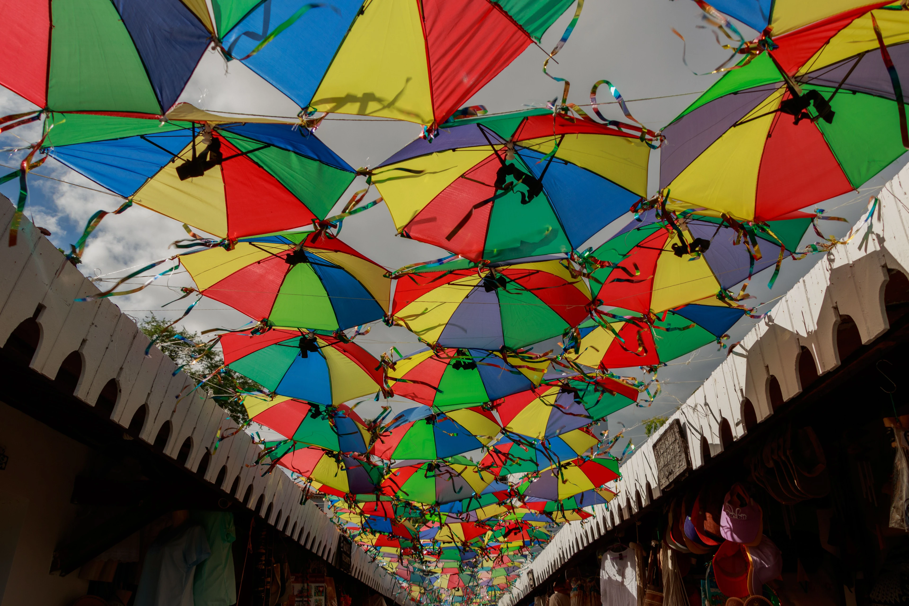 Brightly colored frevo umbrellas form a canopy over a craft passage in Olinda