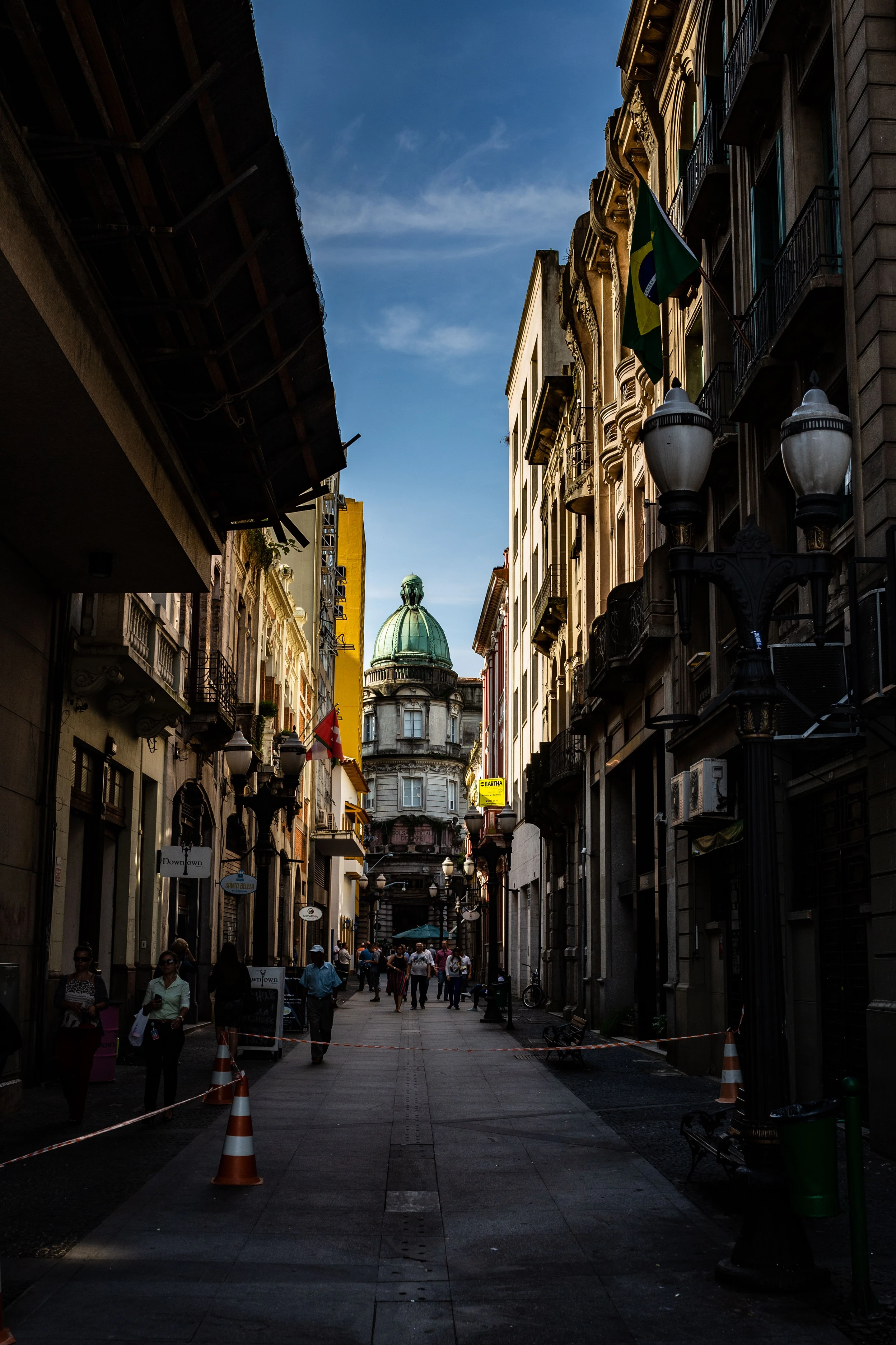 Pedestrians and Brazilian flags between historic façades in Santos