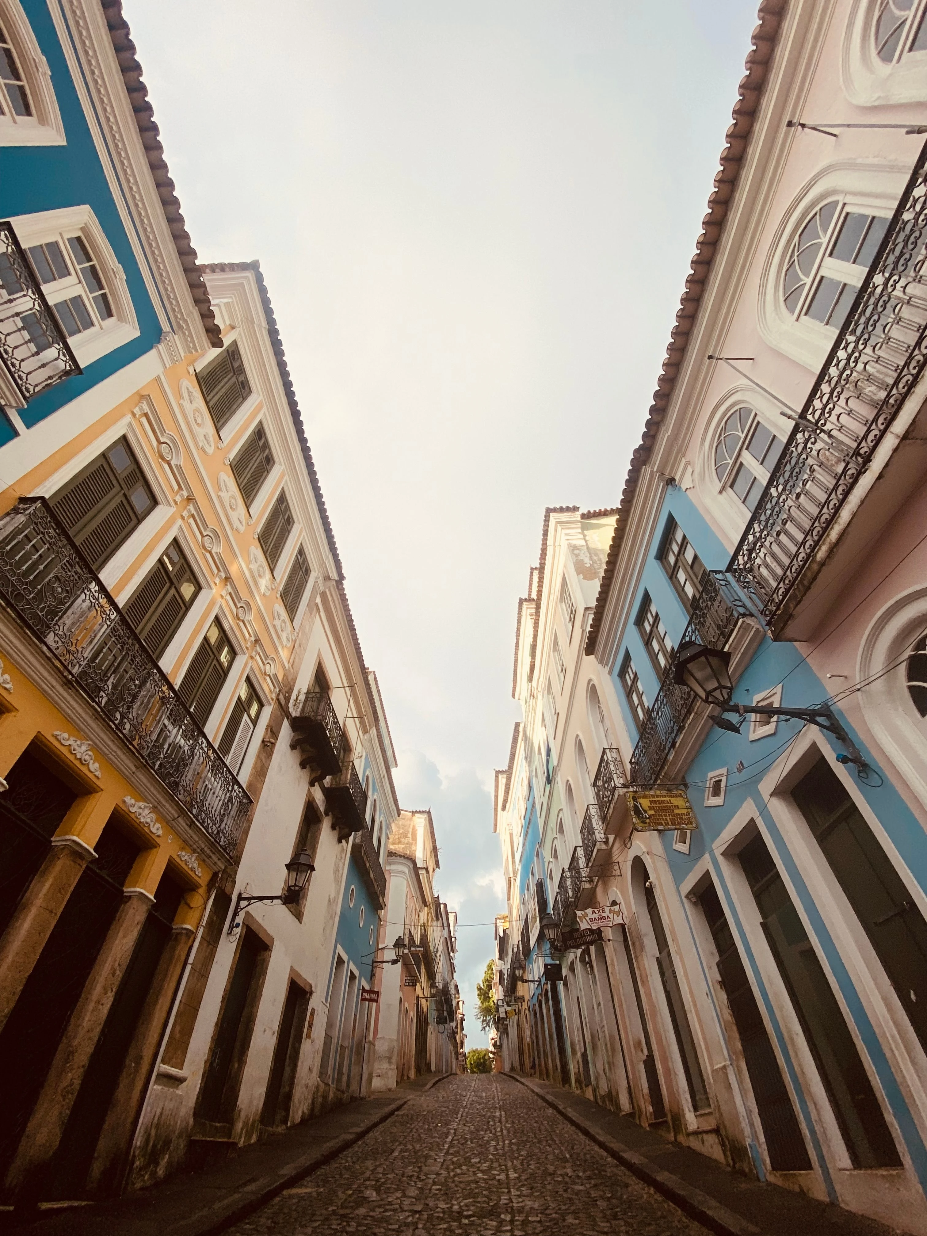 Colorful historic houses rise along a narrow Salvador street