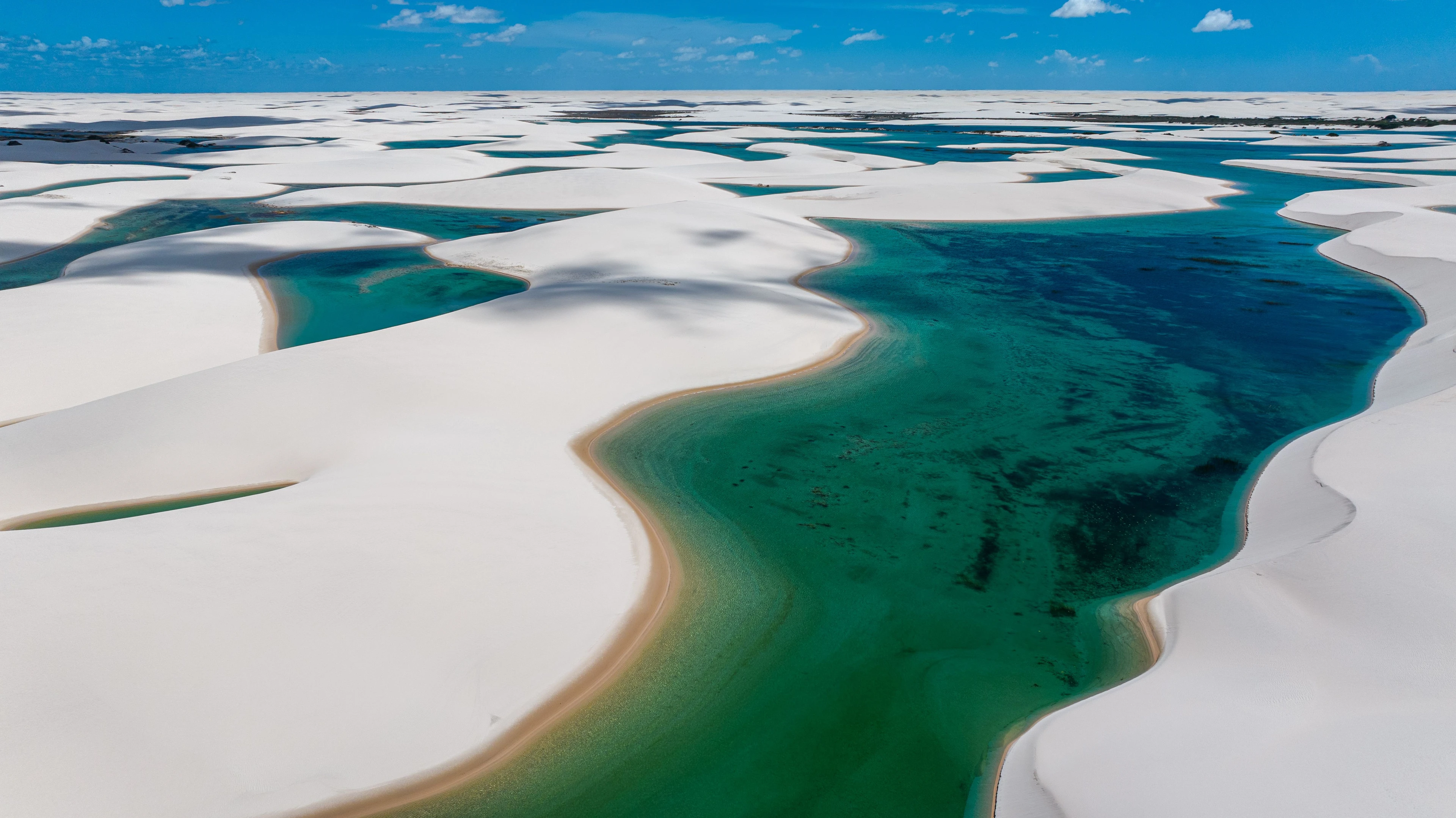 Turquoise lagoons winding between sculpted white dunes