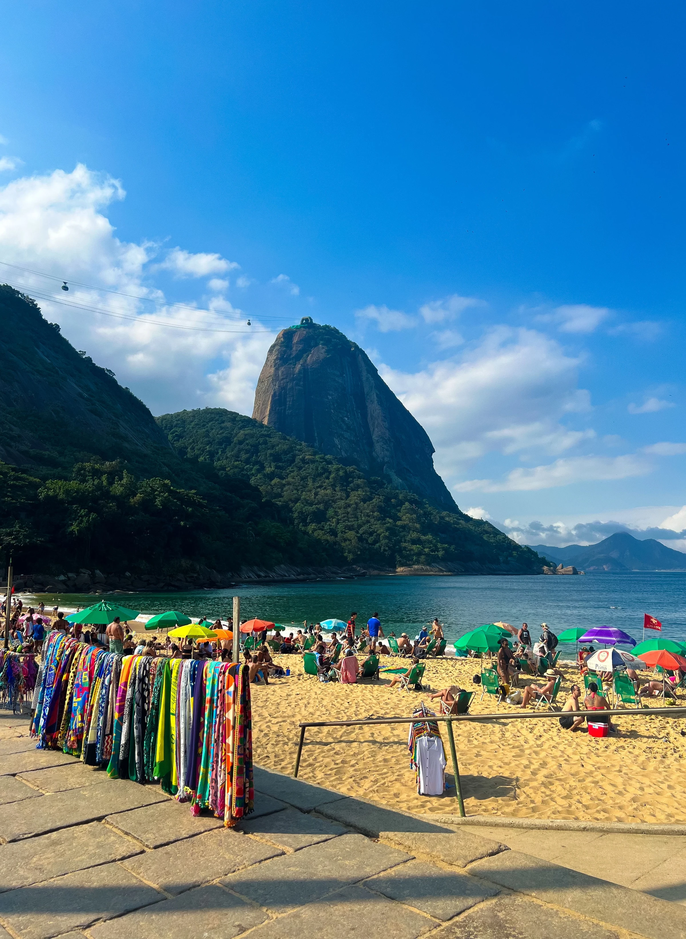 Vibrant beach scene at Praia Vermelha with Sugarloaf Mountain in Rio de Janeiro.
