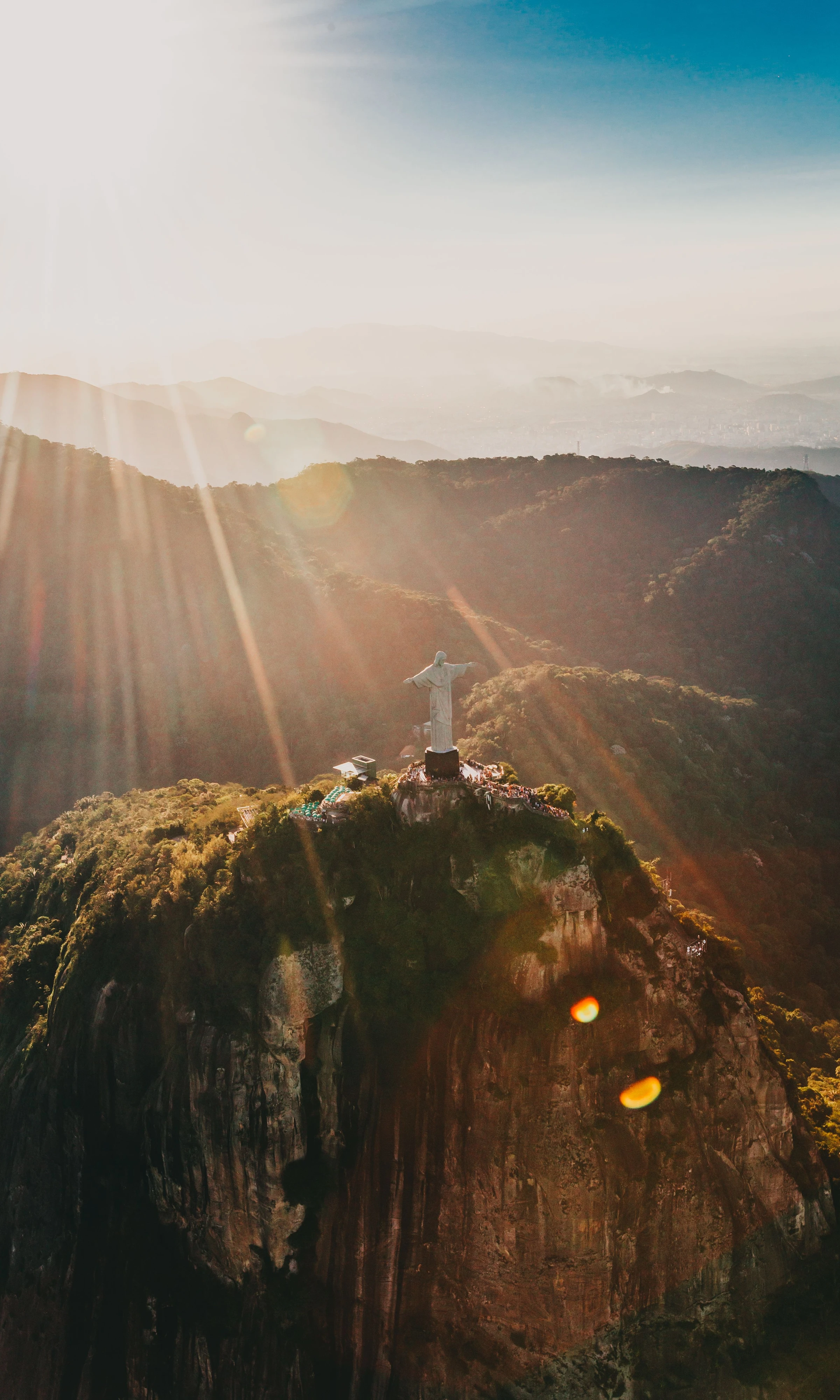 Sunlight crosses the forested ridge around Christ the Redeemer on Corcovado.