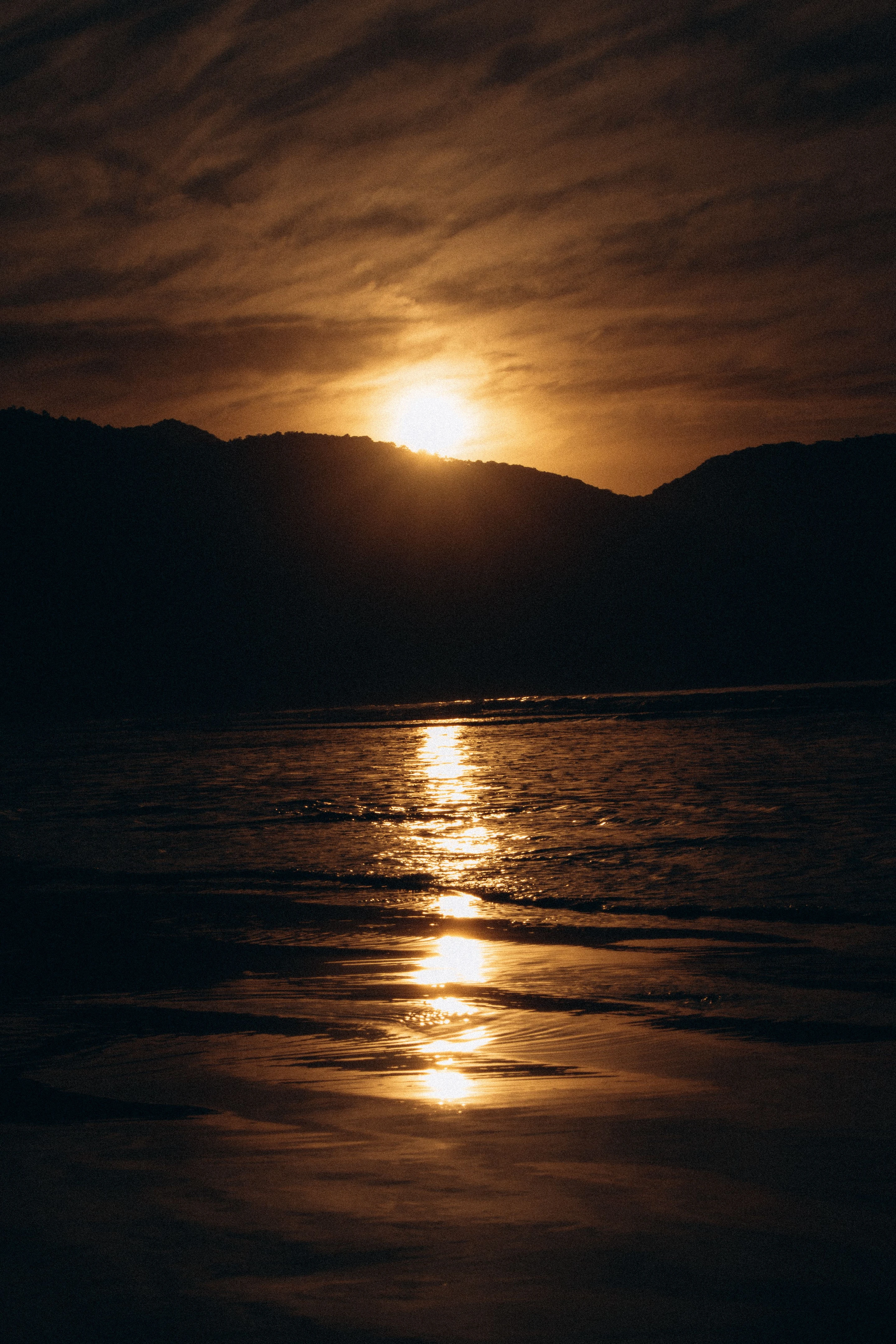 Warm sunset light reflected across the water at Ubatuba