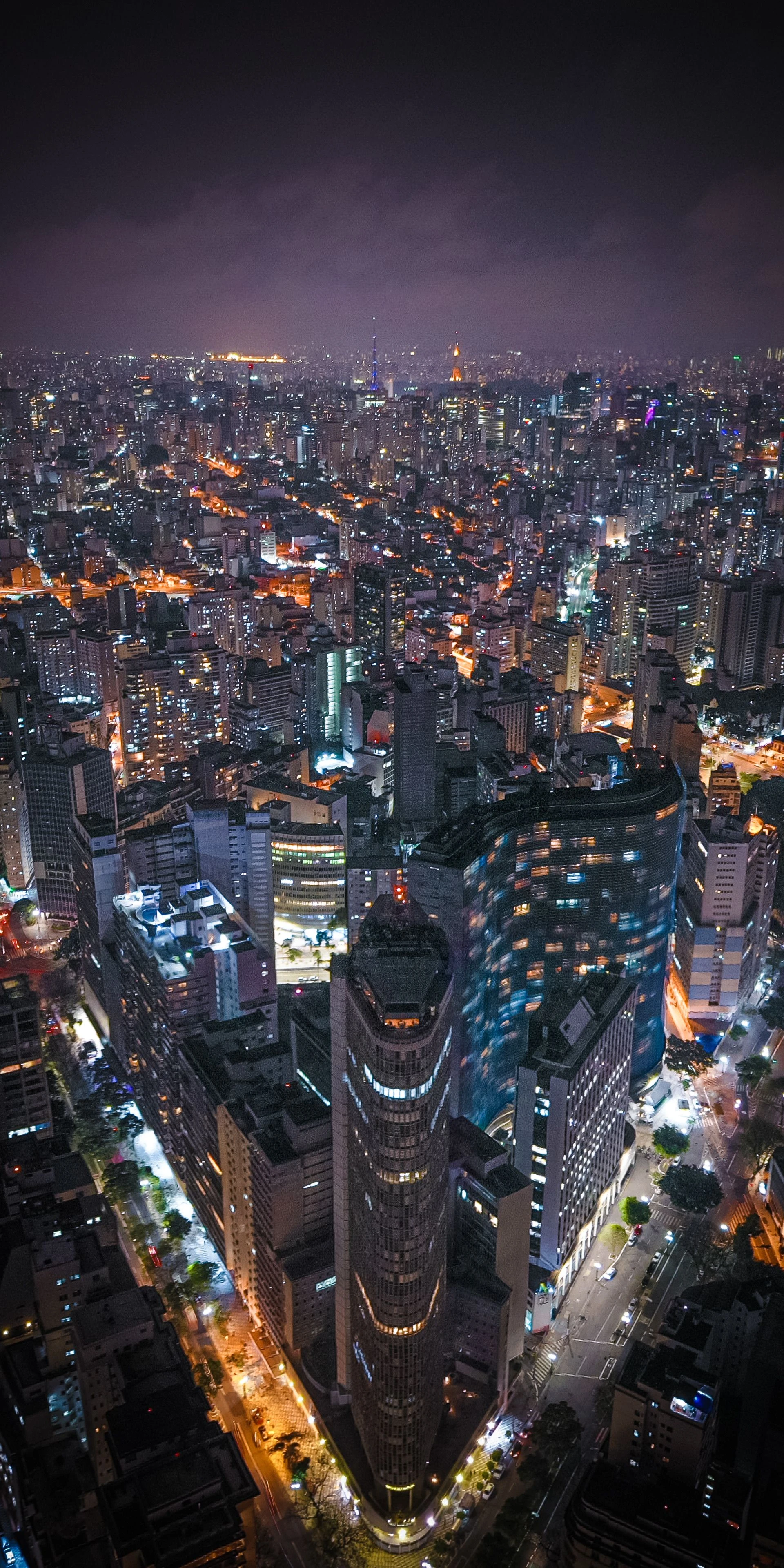 Illuminated towers and street patterns extend across São Paulo at night