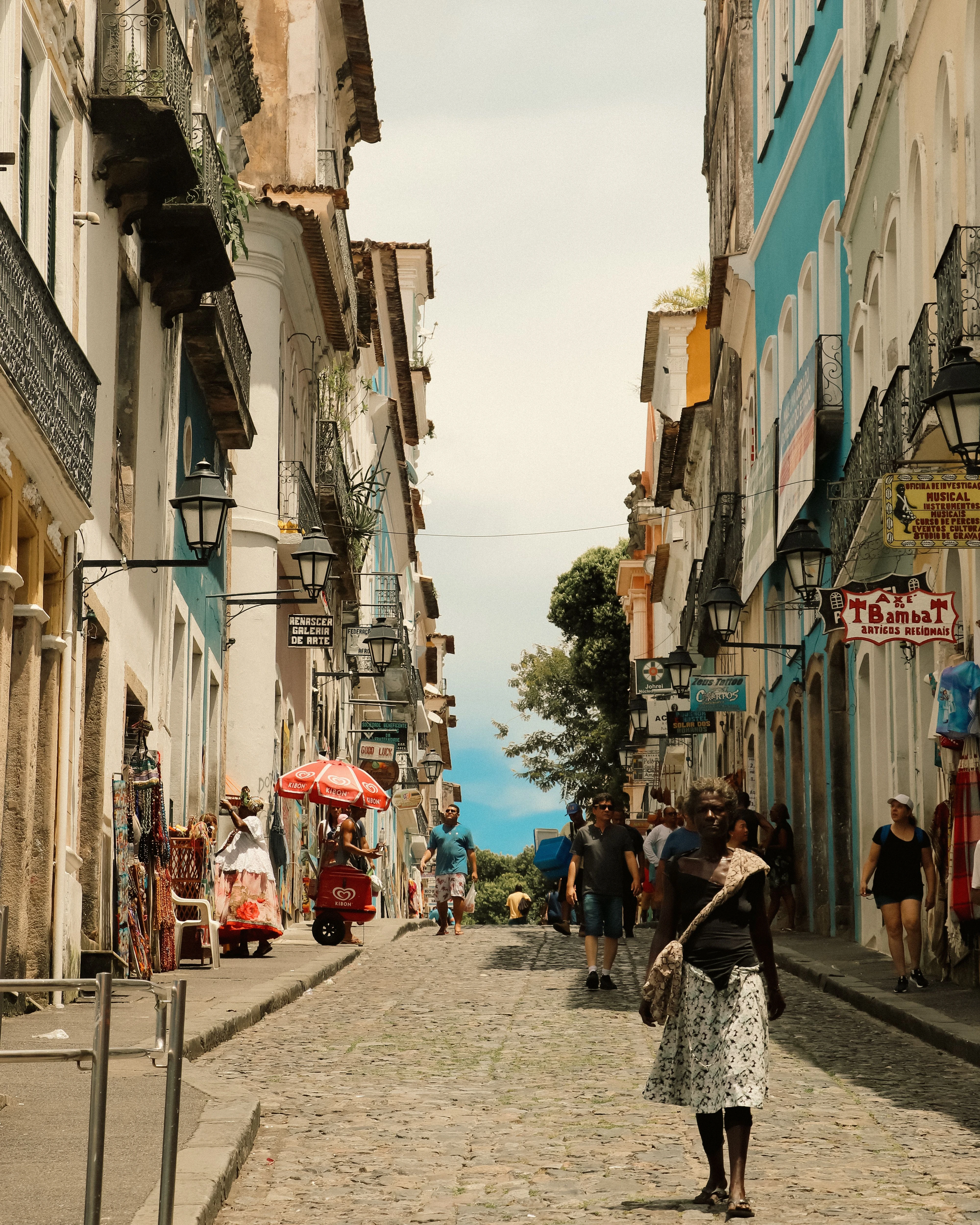 Pedestrians and shops line a colorful street in Salvador's Pelourinho district