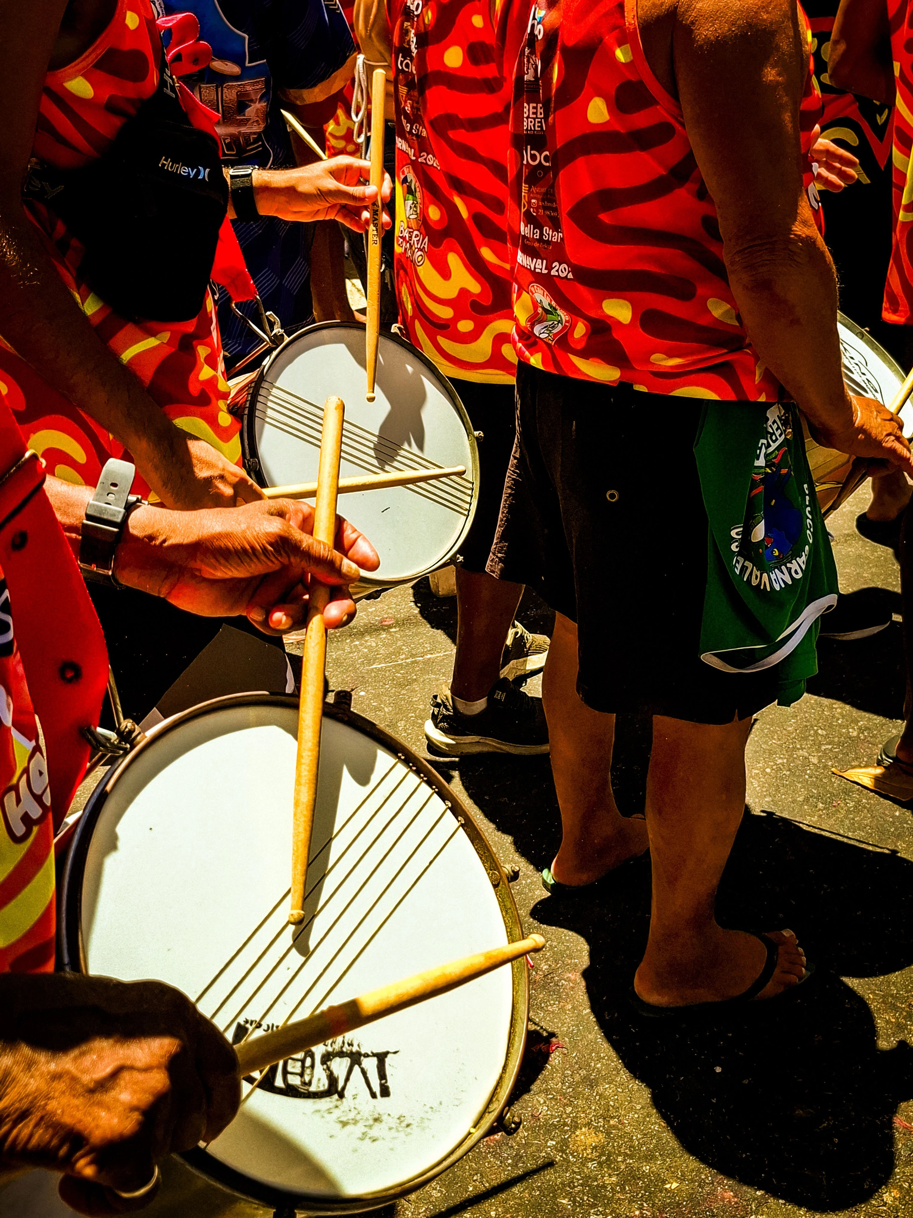 Drummers in red and yellow clothing playing at a Rio street carnival
