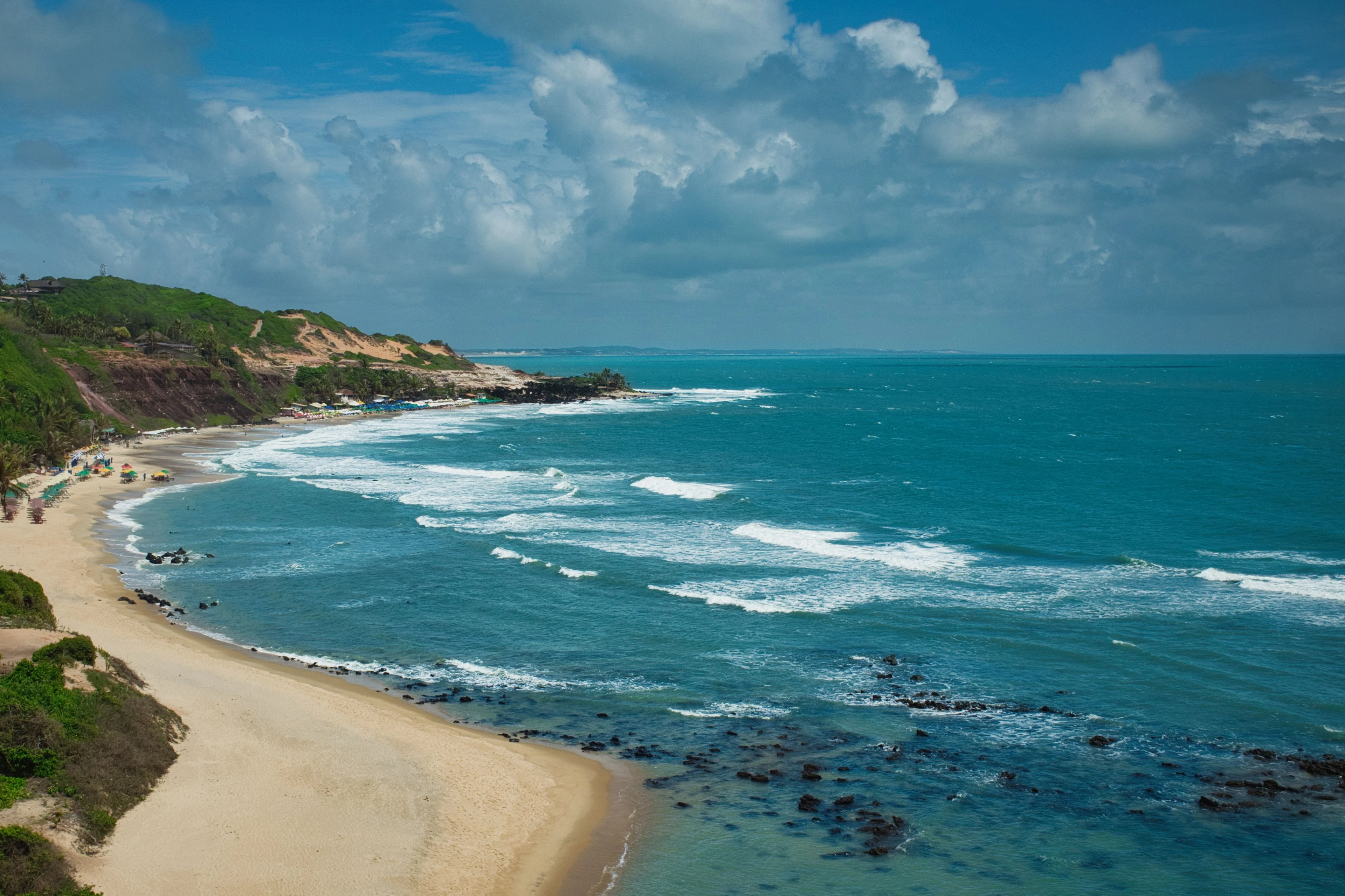 Bright Atlantic waves sweep around the cliff-lined Pipa coastline