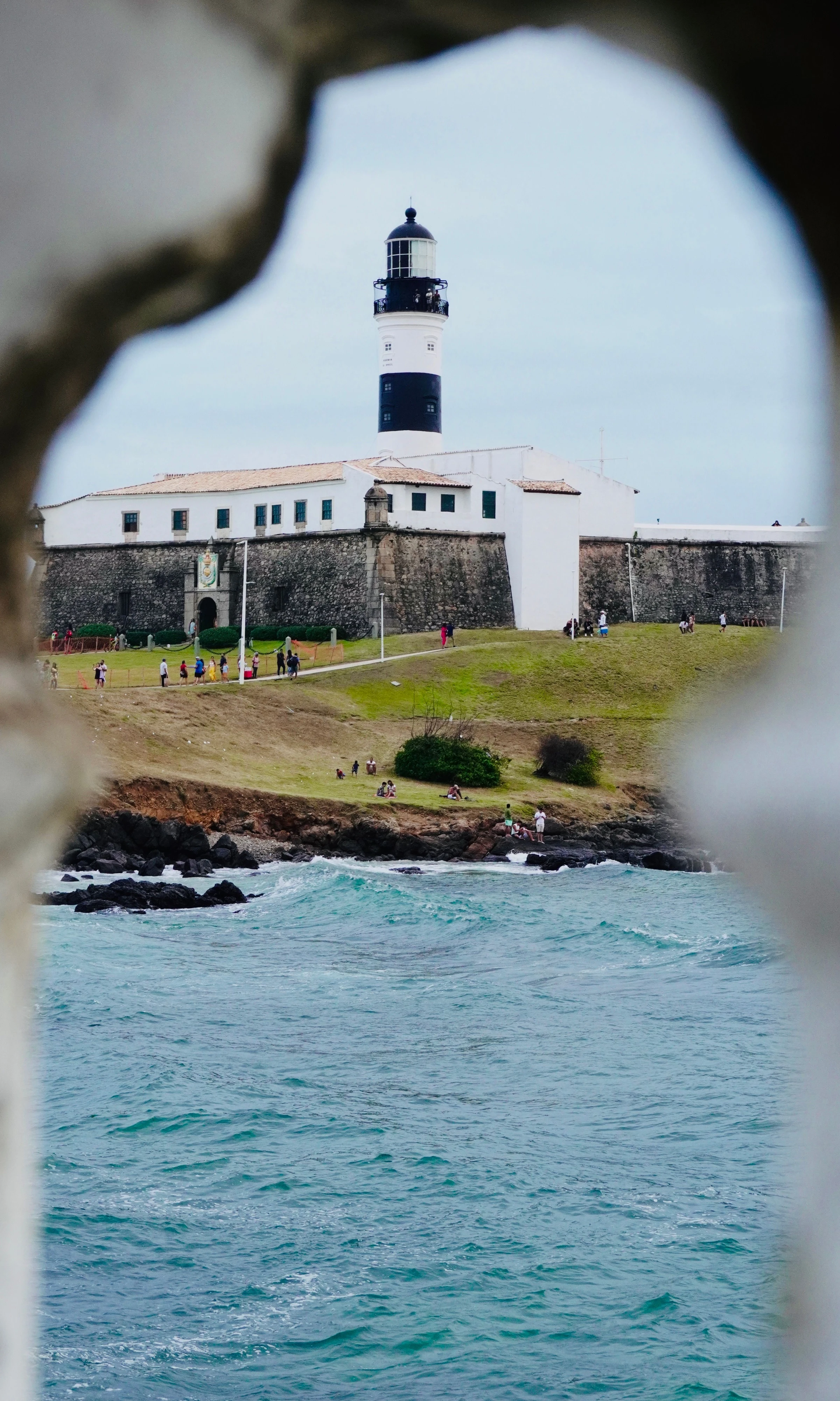Salvador’s Farol da Barra is framed by a stone opening above the ocean.