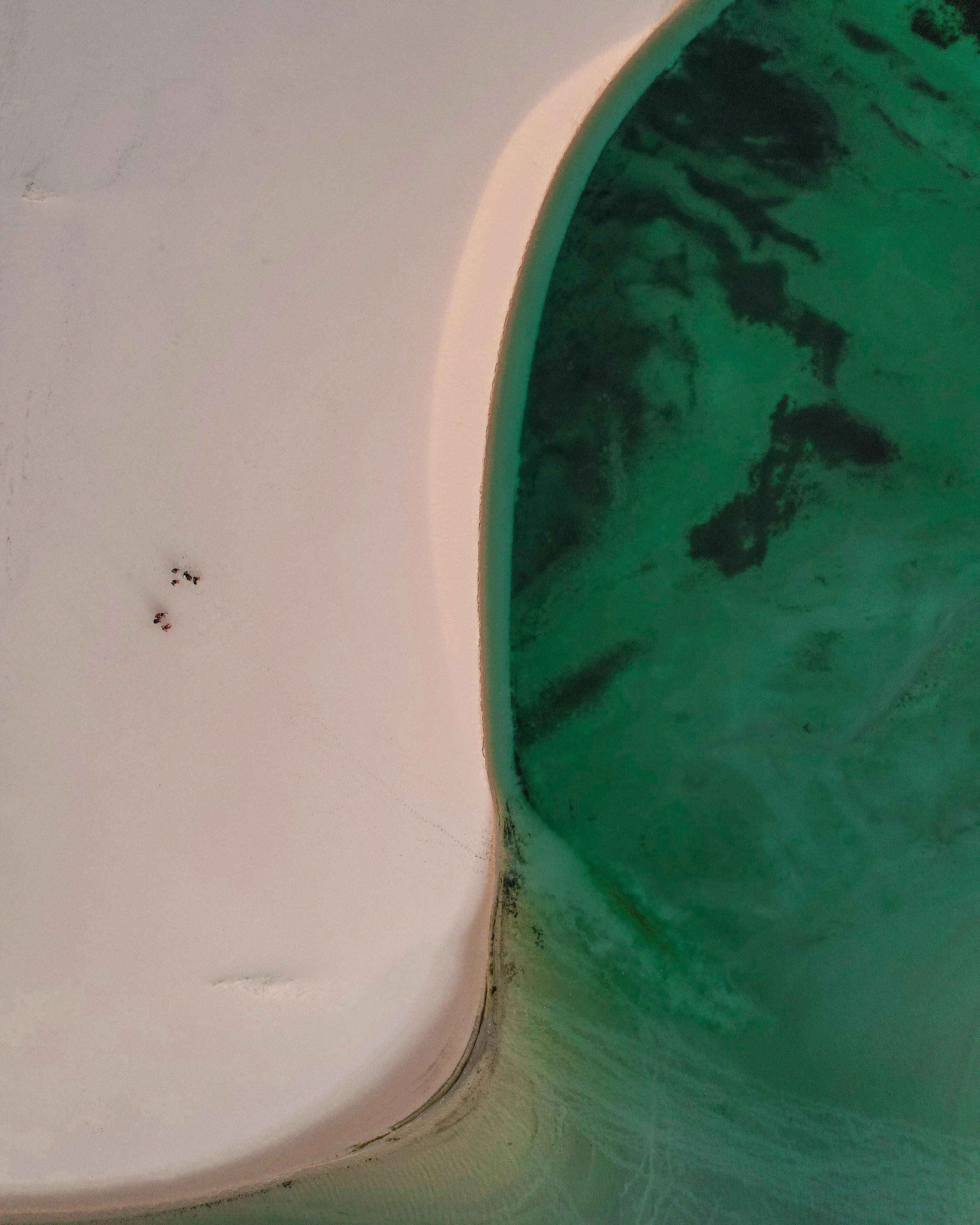 An aerial view of blue lagoons between sweeping sand dunes at Lençóis Maranhenses