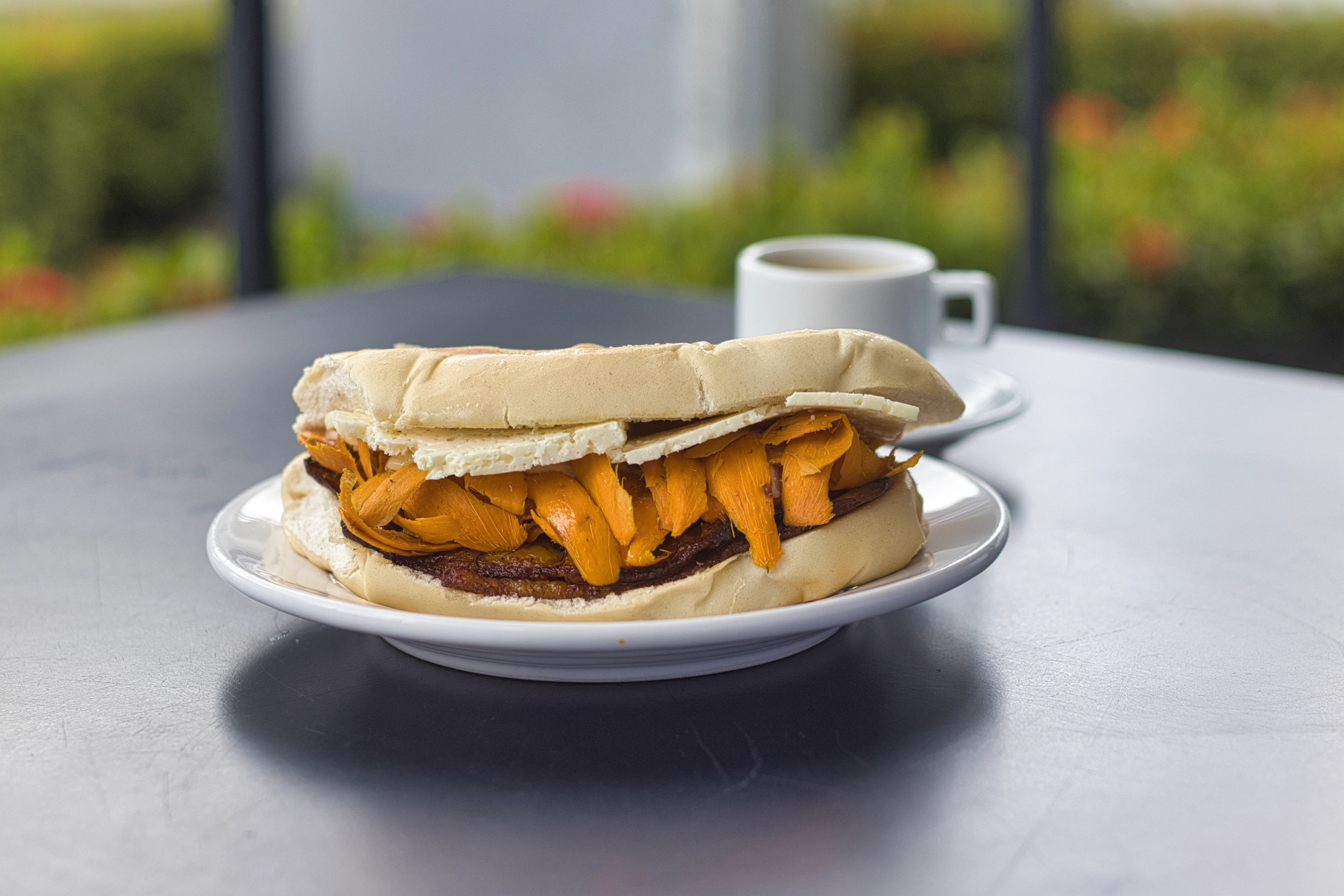 A cheese-filled sandwich and coffee served at a table in Manaus.