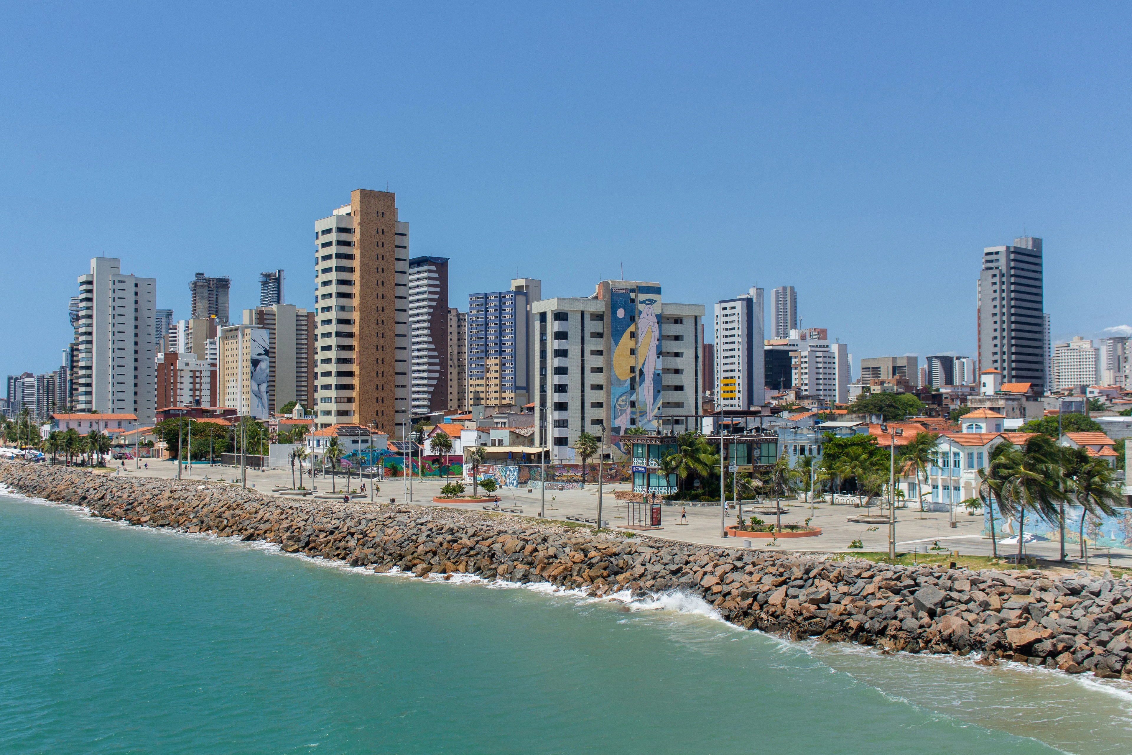 Murals, buildings and palms line the Iracema waterfront beside turquoise water