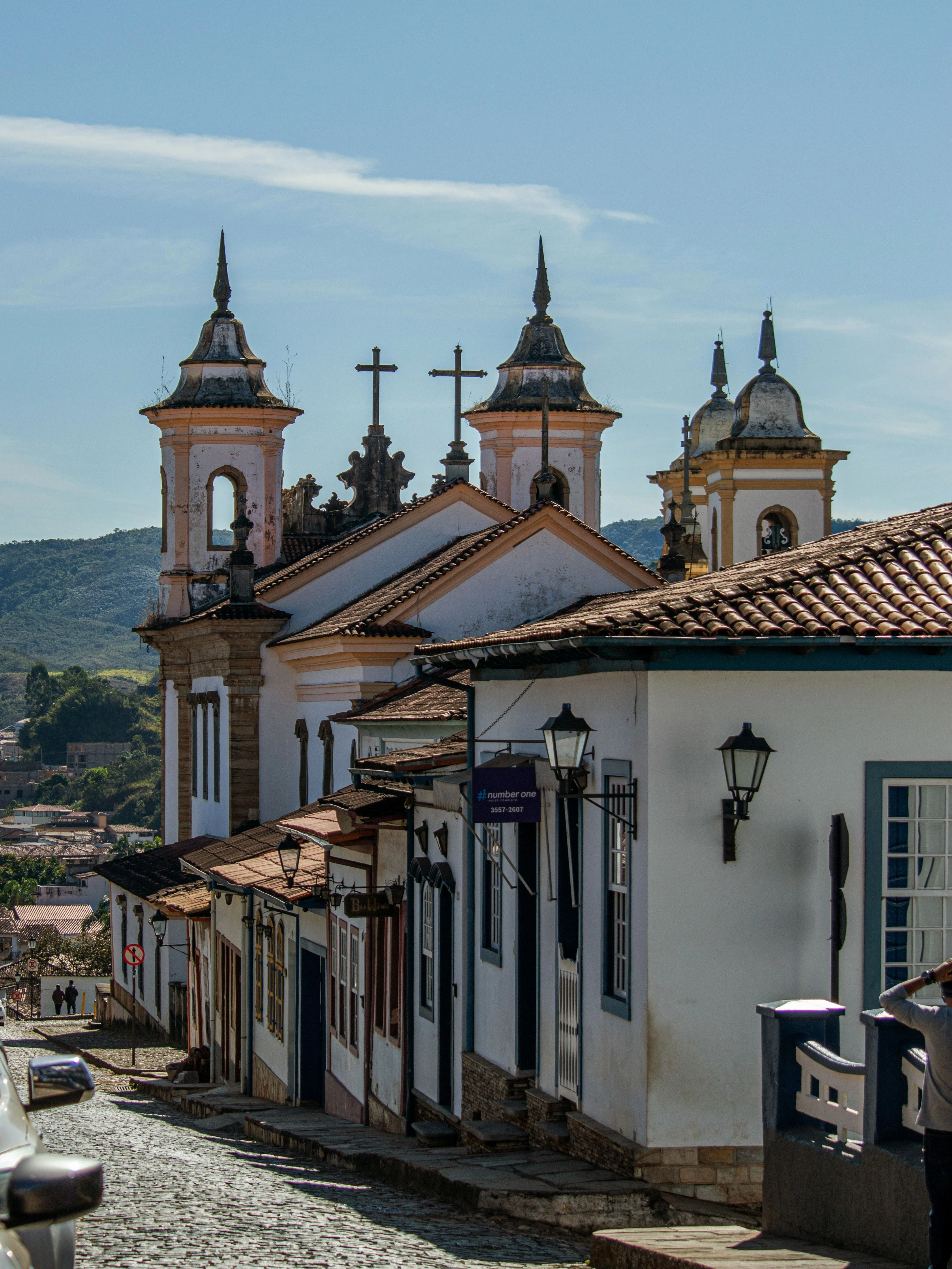 Historic church towers stand over a steep Ouro Preto street