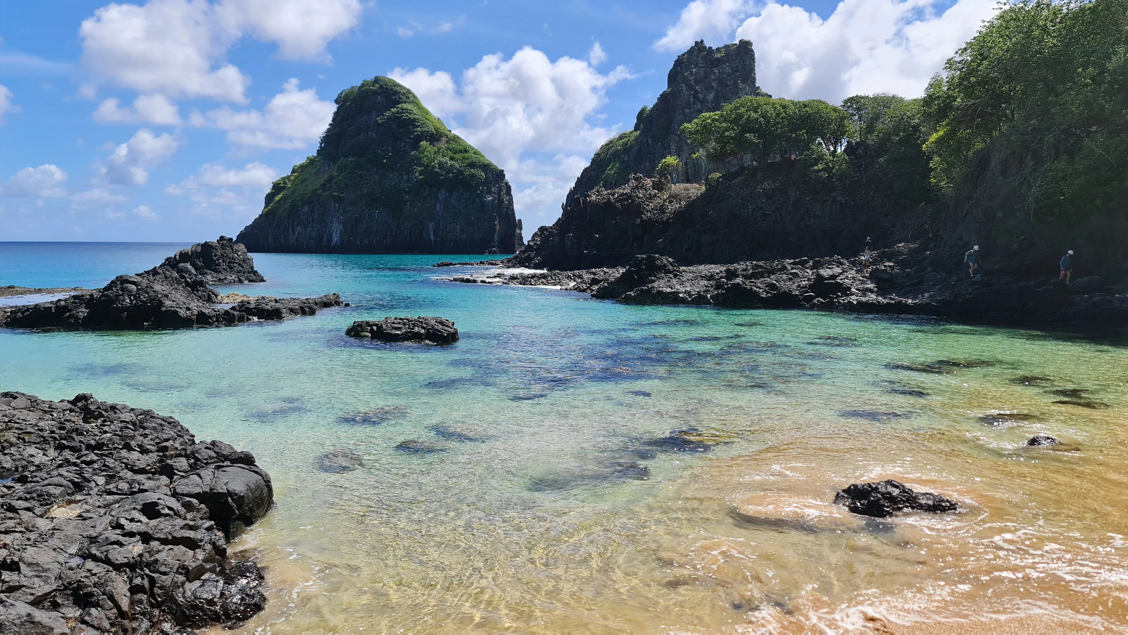 Bright blue water meets the rocky coastline of Fernando de Noronha