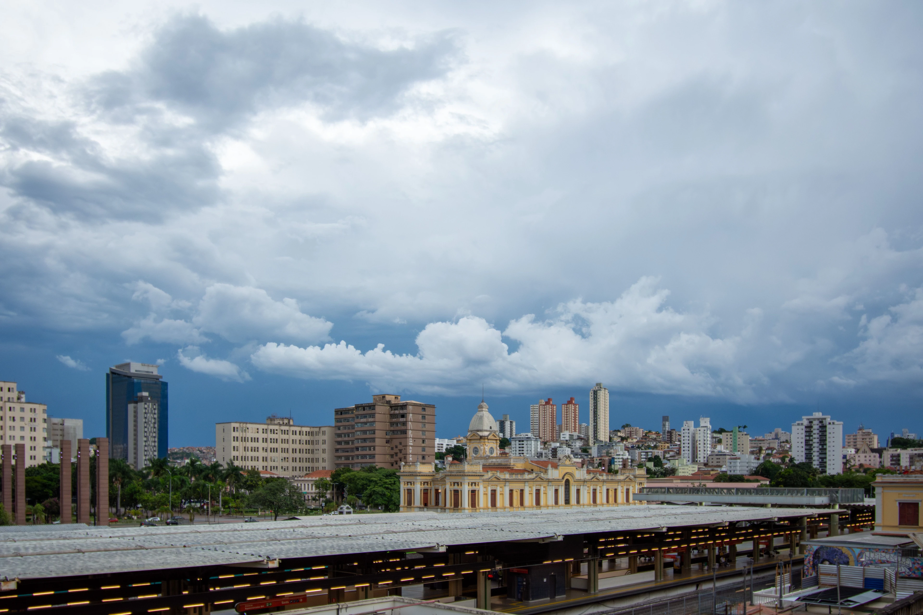 Railway tracks lead toward Belo Horizonte's historic station beneath dramatic clouds