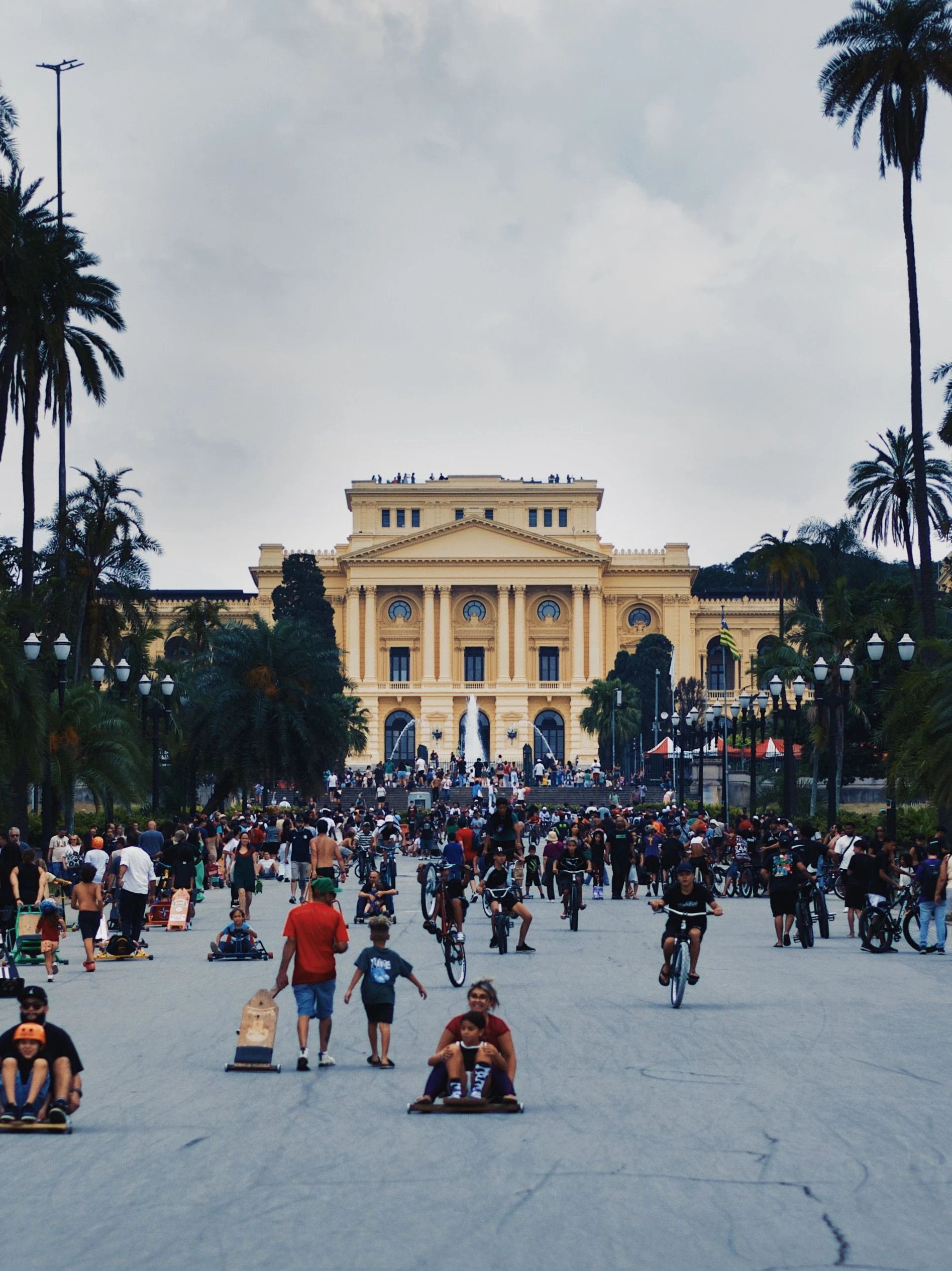 People cycle near the historic buildings of Parque da Independência in São Paulo, Brazil.