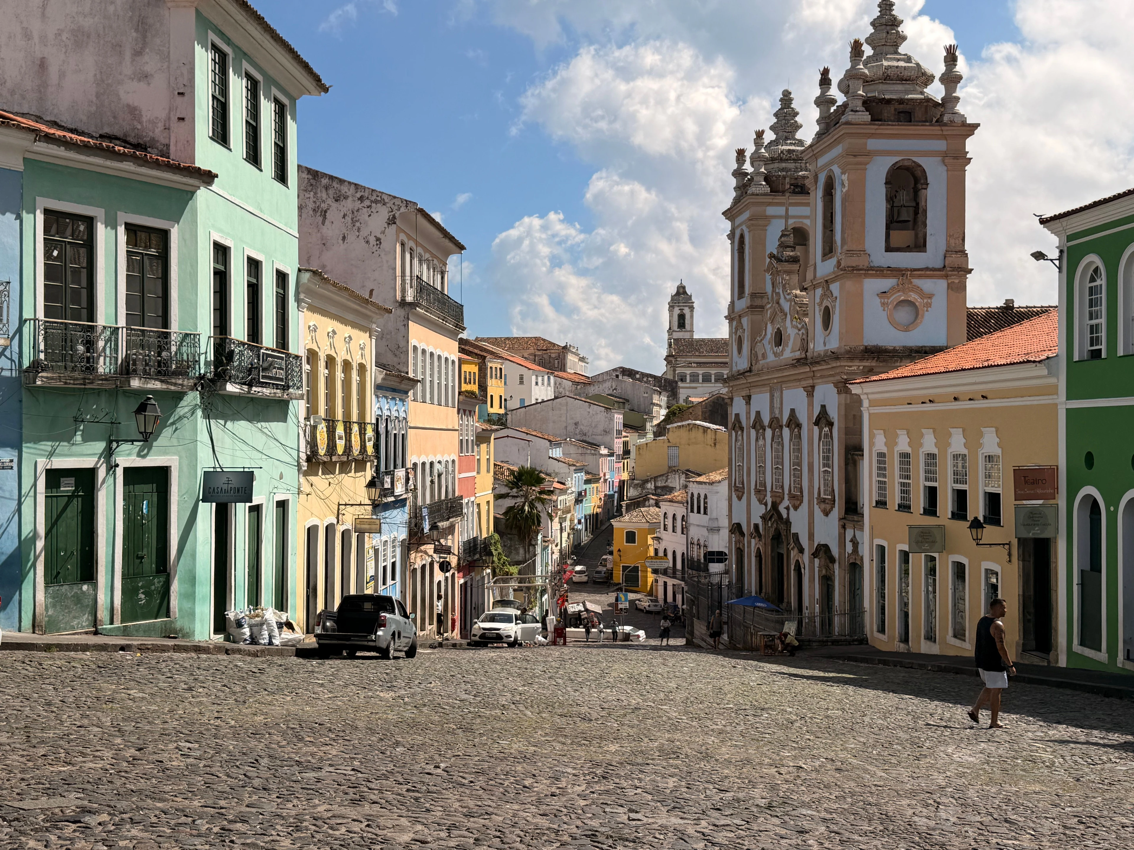 Colorful historic buildings and church towers along a sloping street in Pelourinho