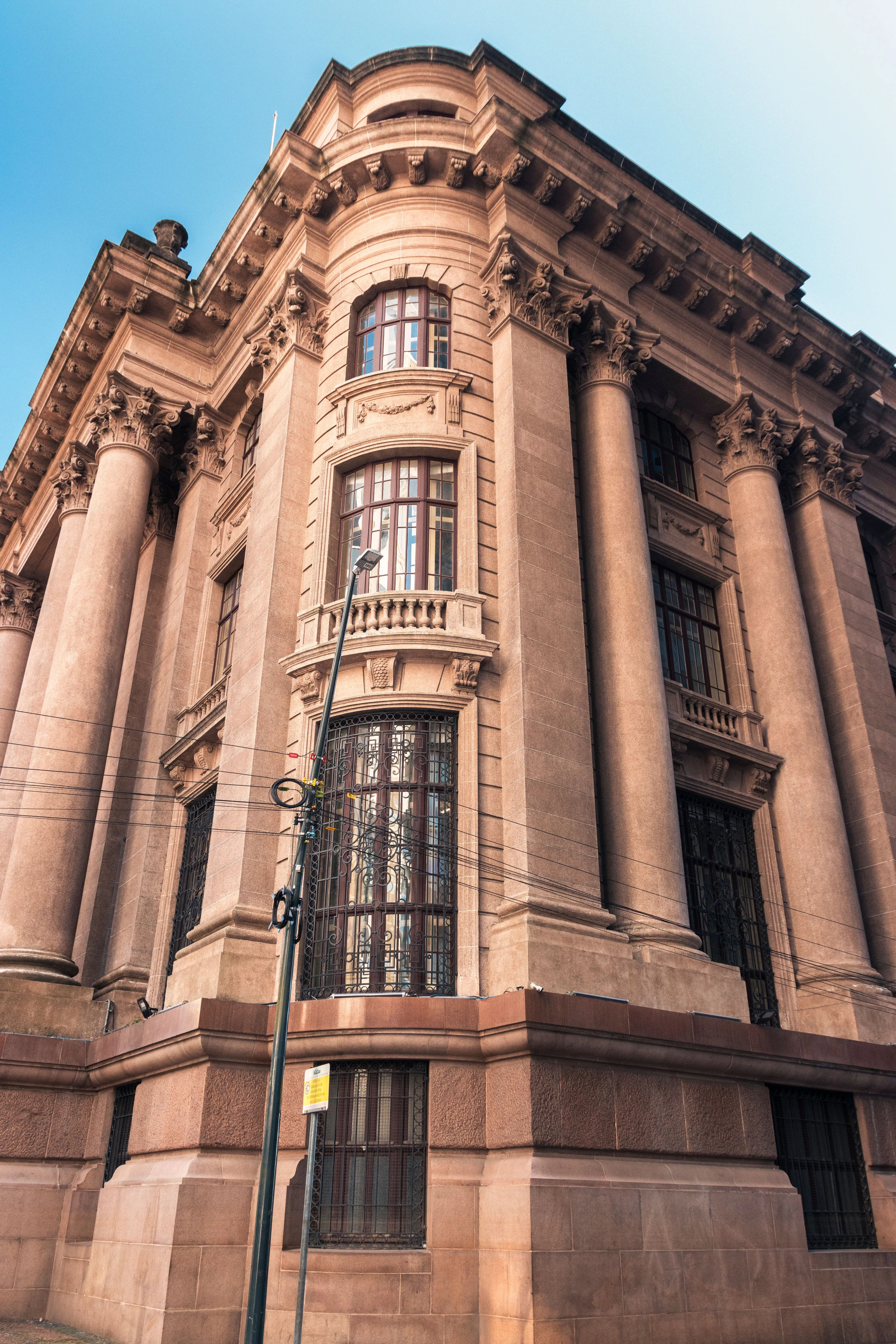 Ornate columns and stone details of a historic Porto Alegre building seen from below.