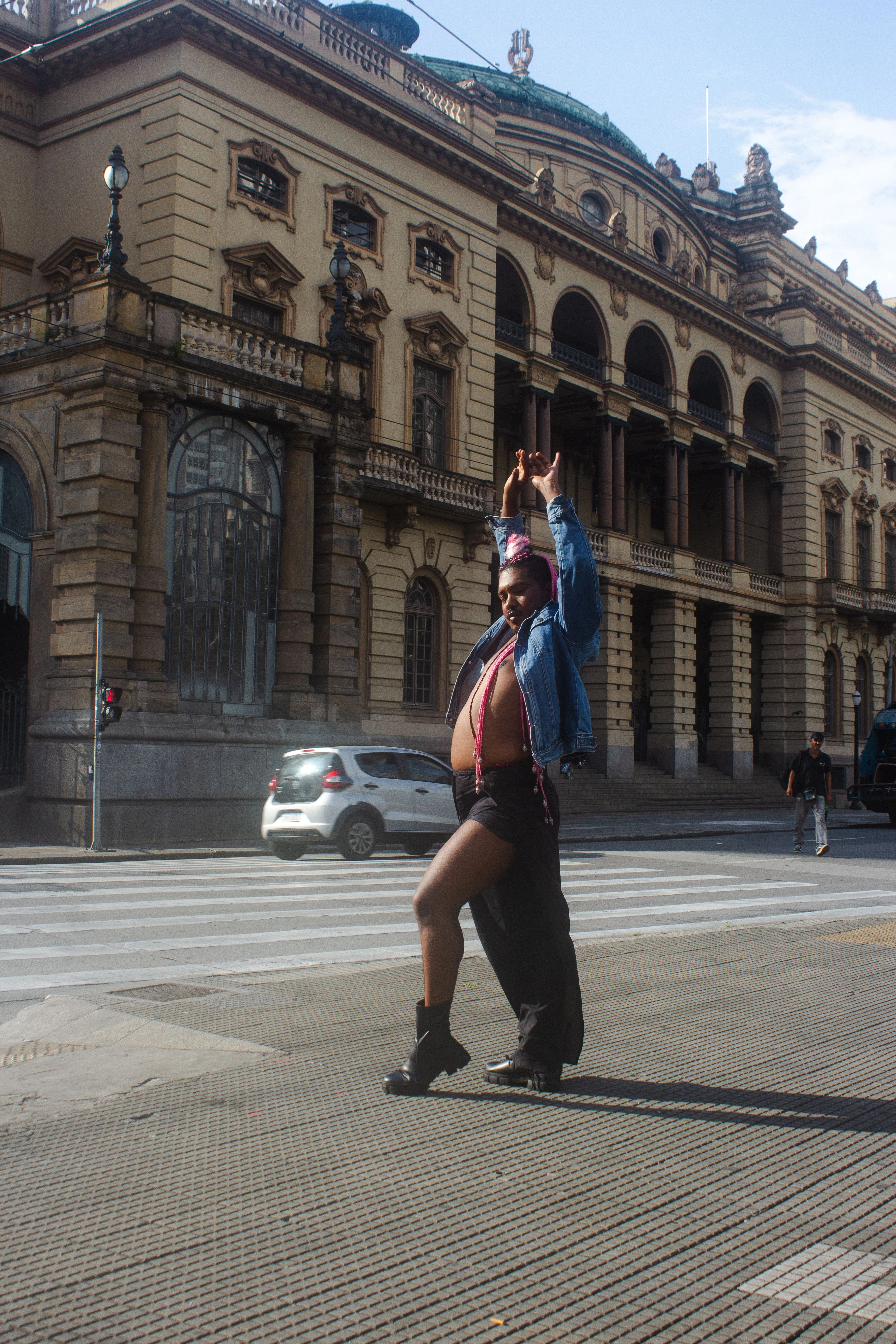 A dancer moving in front of the historic Theatro Municipal in São Paulo