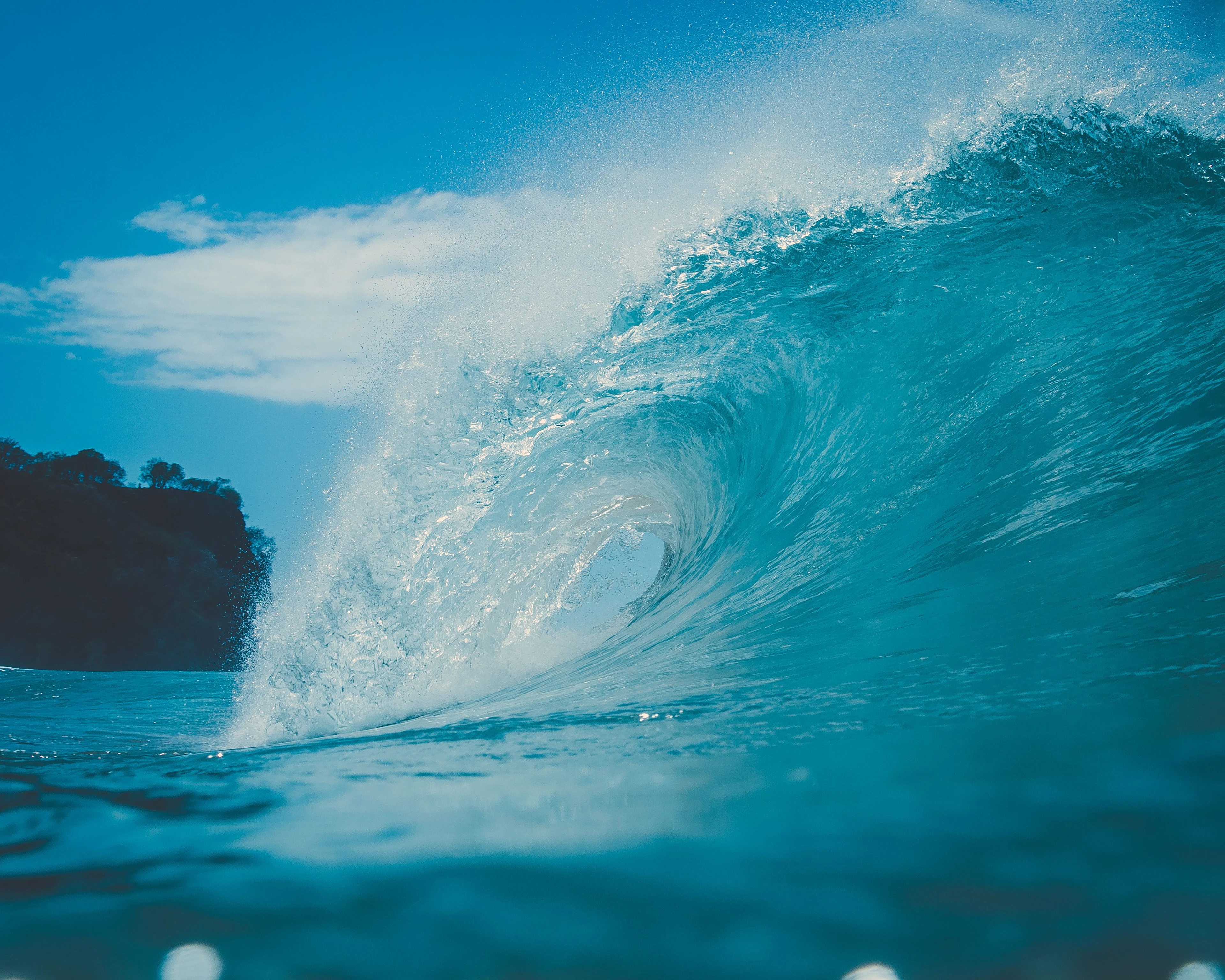 A translucent ocean wave rises at water level off Fernando de Noronha
