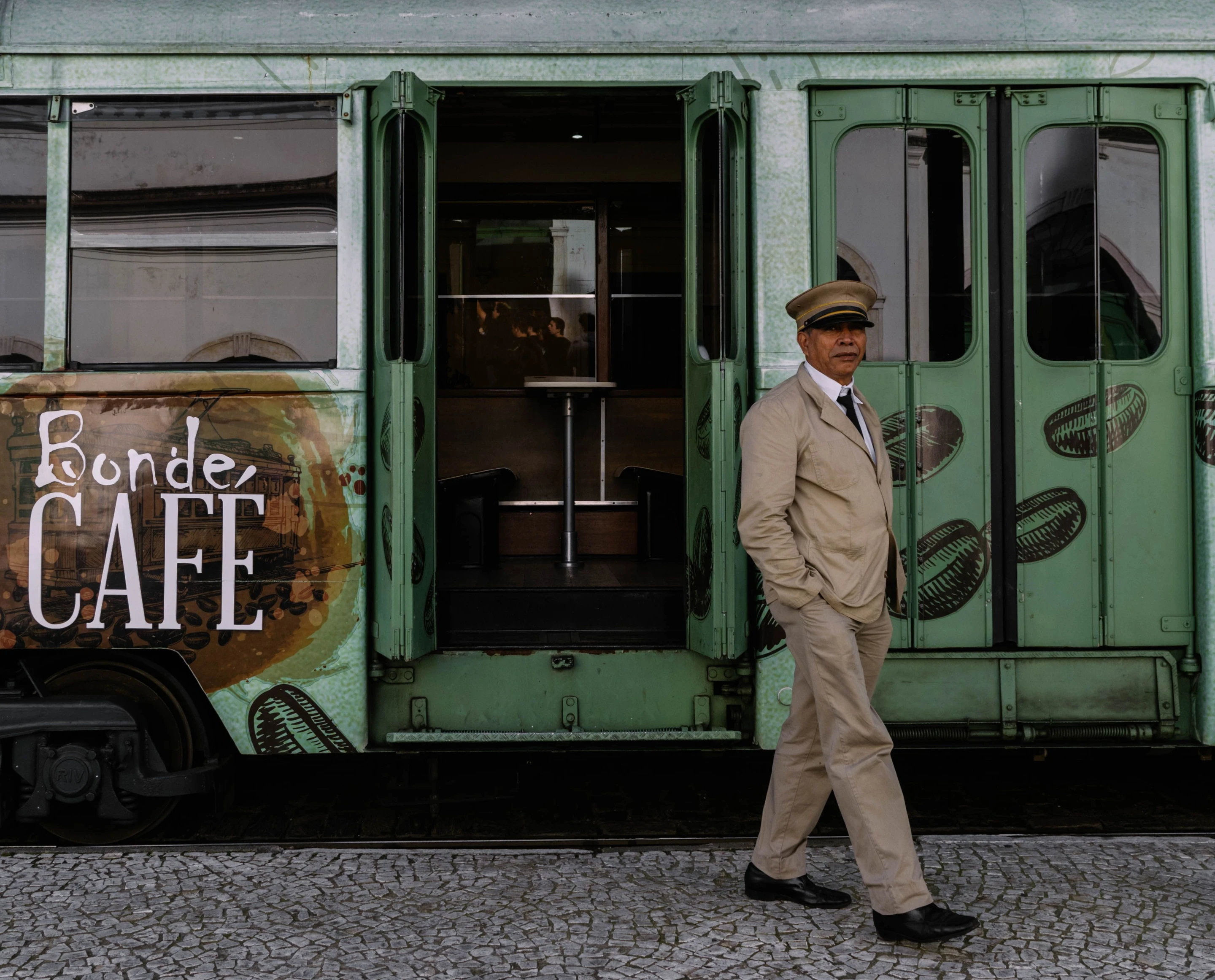 A uniformed conductor beside the colorful Bonde Café heritage tram