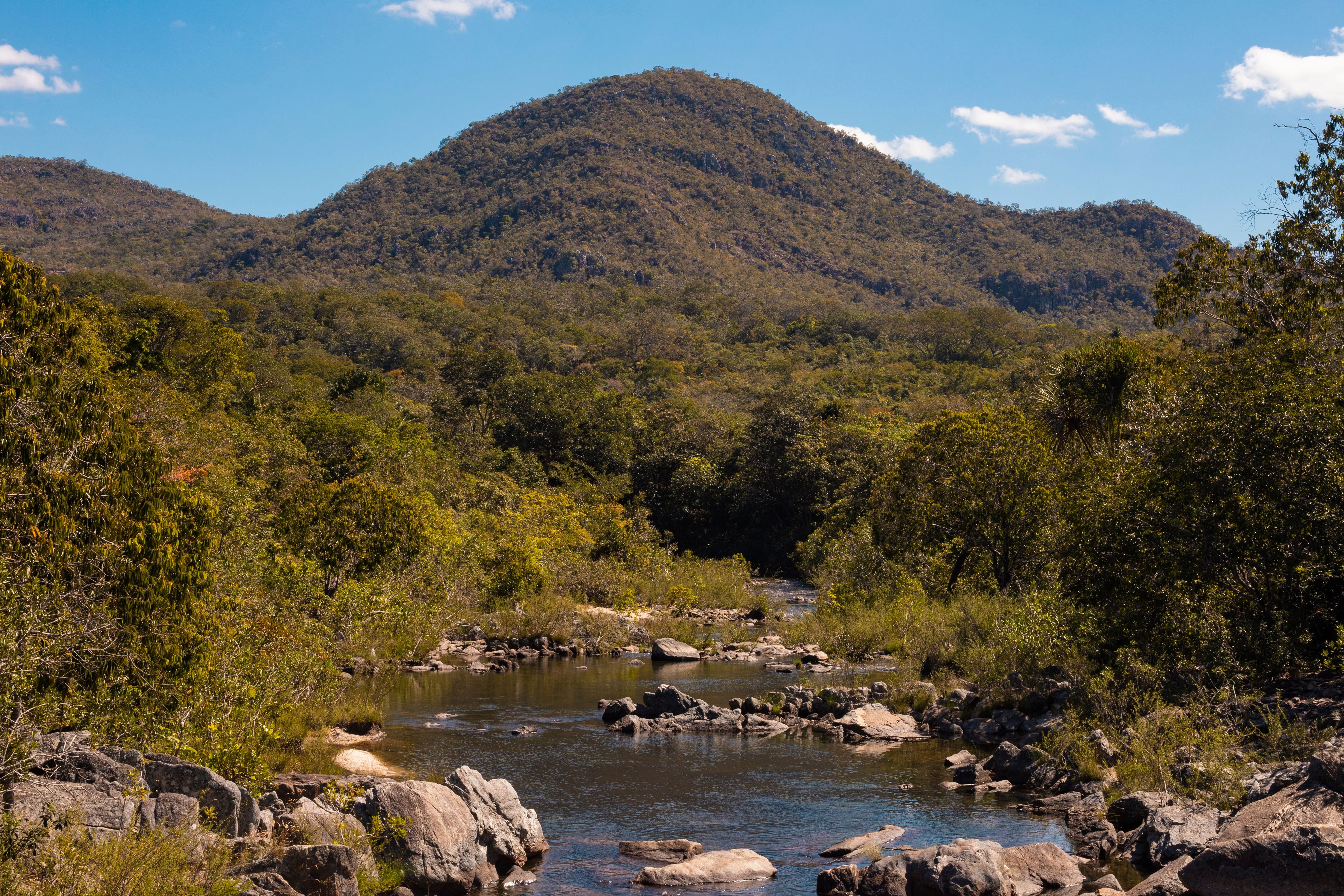A rocky river runs beneath open hills in Goiás, shown as regional landscape context.