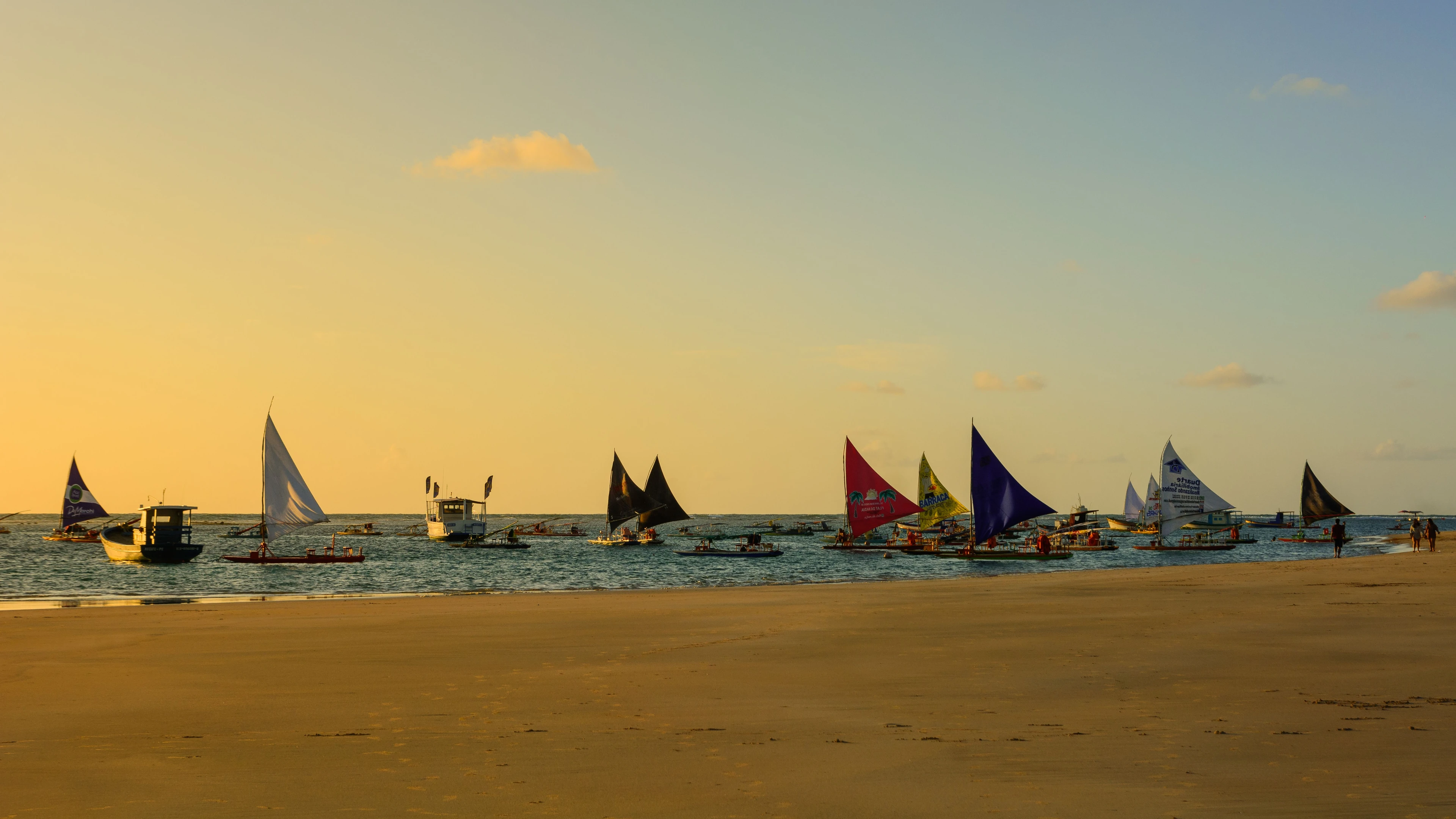 Colorful jangada sails catch golden coastal light at Porto de Galinhas