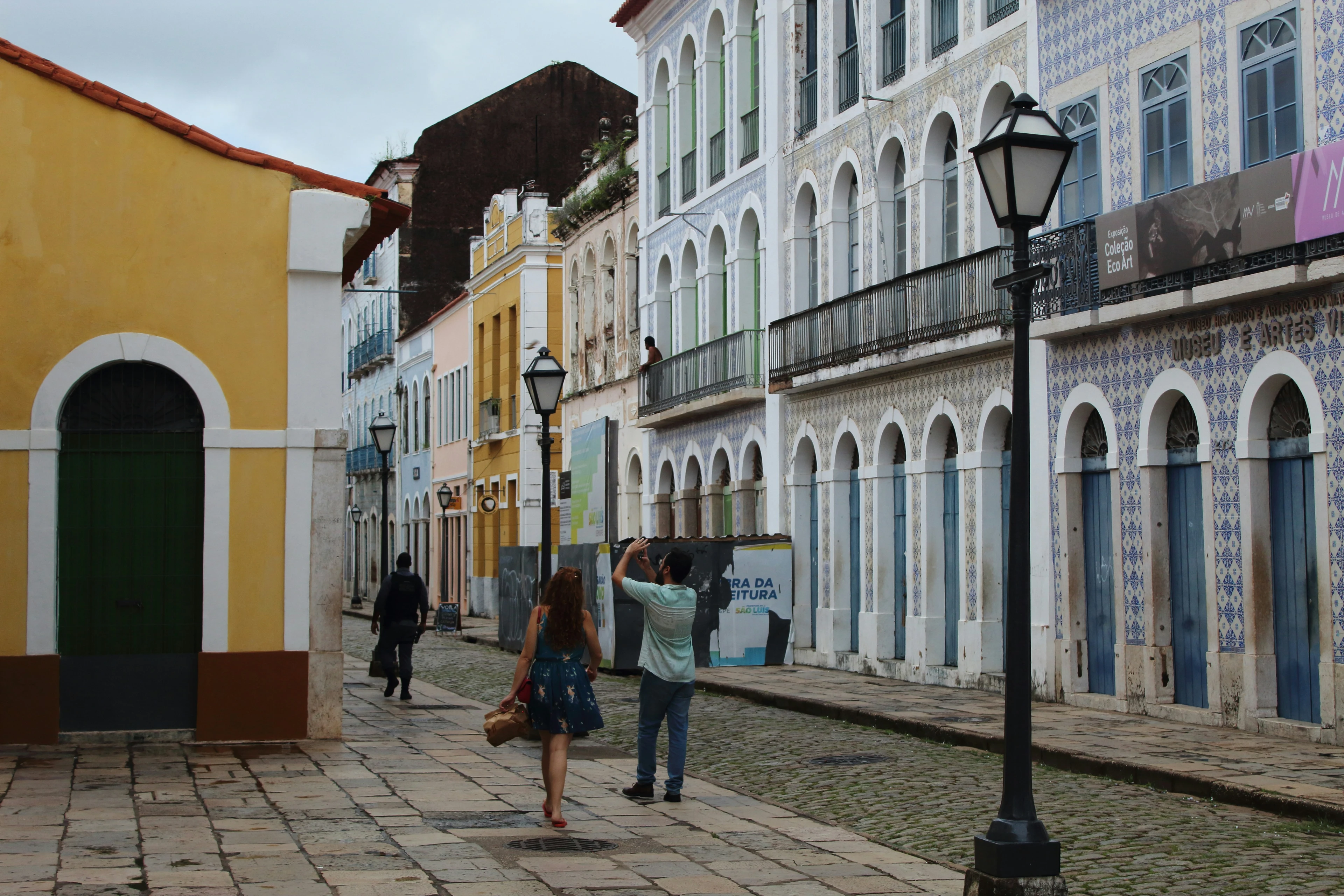People walk between colorful tiled façades in São Luís’s historic center
