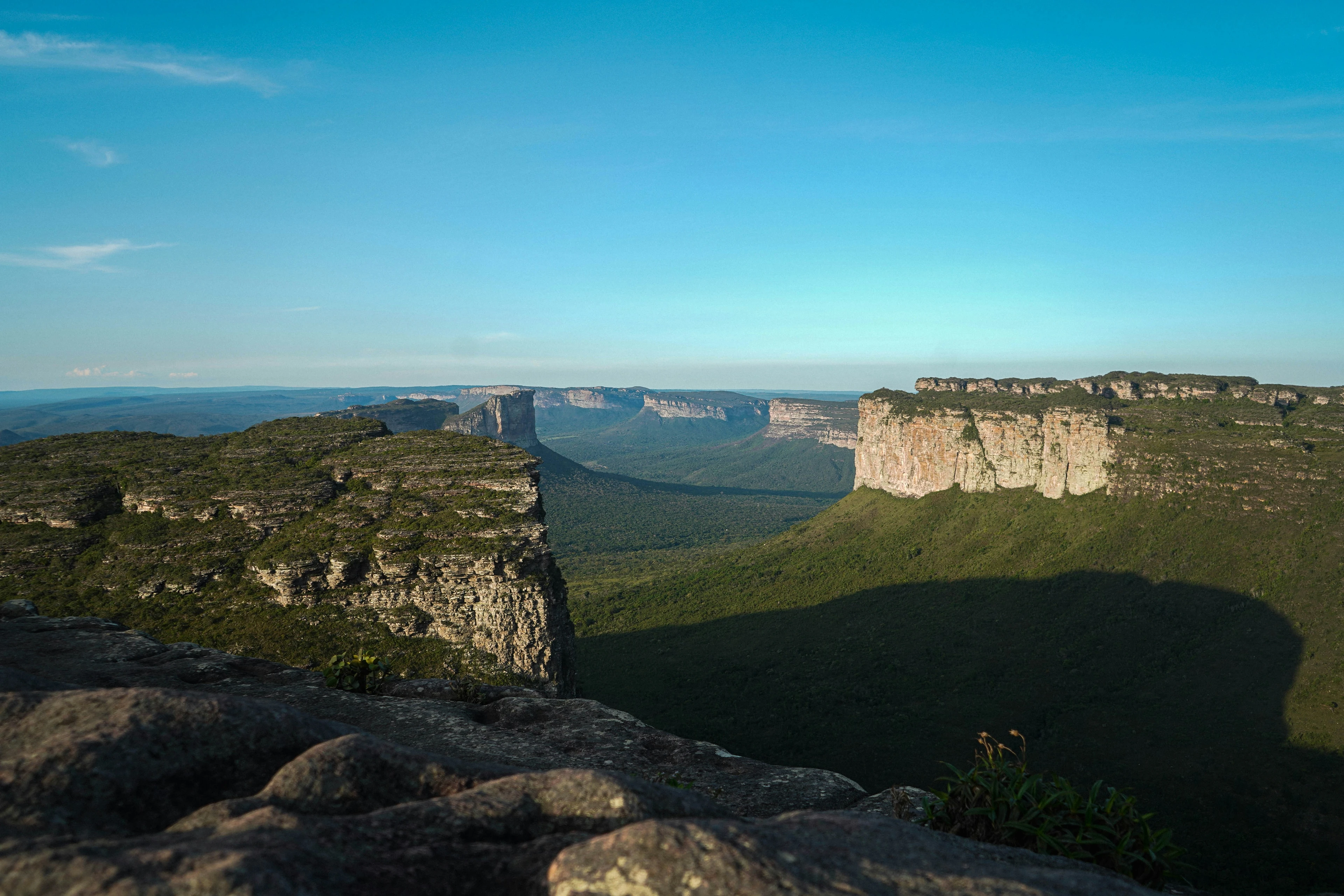 Layered table mountains and deep valleys stretch across Chapada Diamantina in warm light