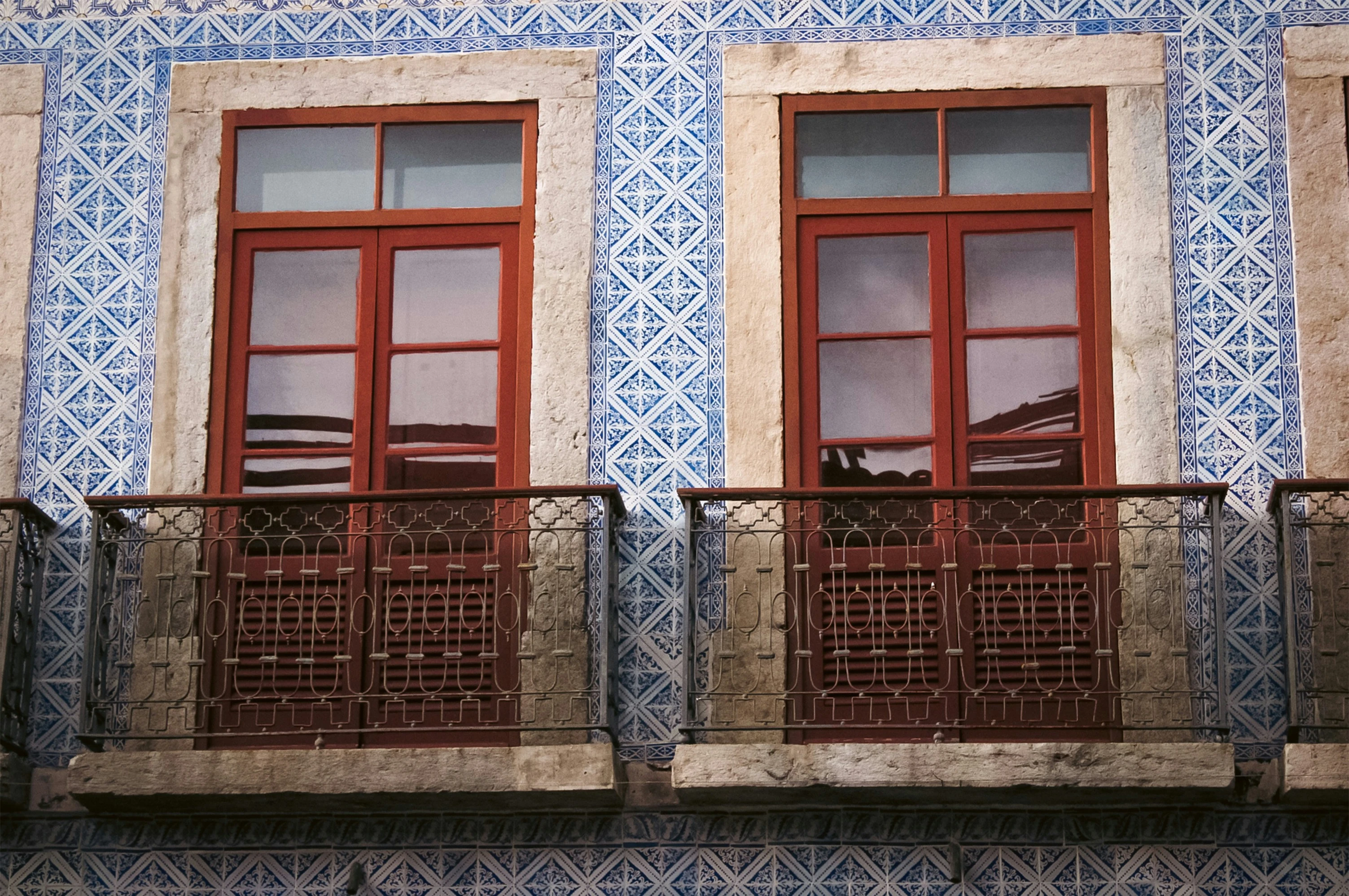 Blue-and-white azulejo tiles, wooden windows and ironwork on a São Luís façade