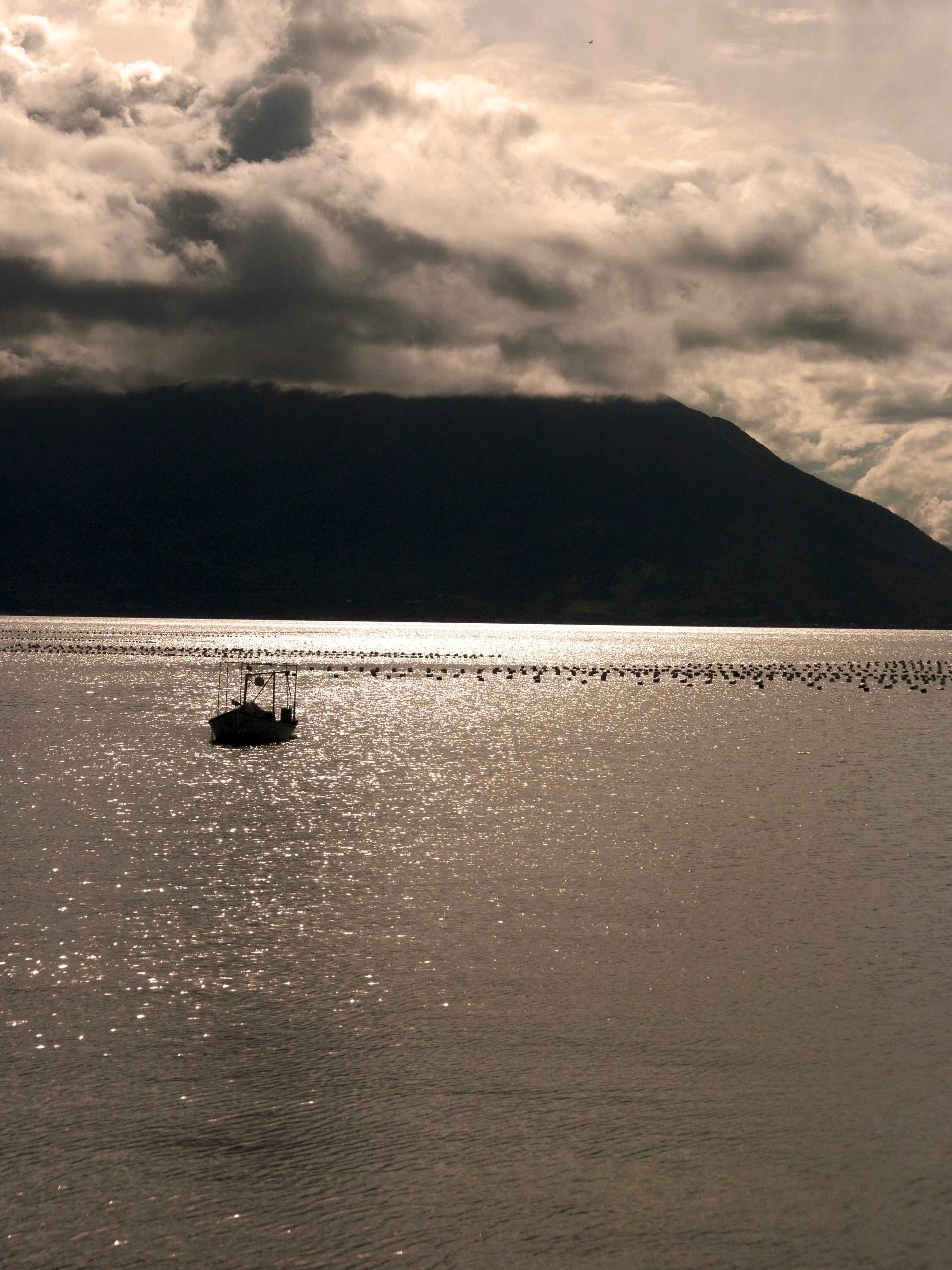 A sailboat beneath dramatic clouds on the bay at Ribeirão da Ilha.